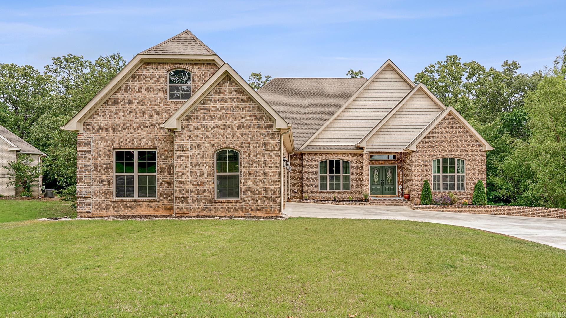 Nestled in Jonesboro's coveted neighborhood, this 5-bed, 3.5-bath home harmonizes elegance, comfort, and convenience. Its expansive layout blends modern family needs with serene wooded surroundings. A spacious den with a cozy fireplace invites gatherings. The basement hosts a kitchenette, living area, and media room for entertaining. Outside, a covered patio offers tranquil woodland views. The gourmet kitchen features granite countertops and a kitchen island. A master suite with an office and walk-in closet provides a private retreat. Upstairs, a versatile bonus room awaits. Quality craftsmanship is evident from built-in shelving to the timeless brick exterior. With a 3-car garage and proximity to schools and amenities, this home epitomizes refined living in Jonesboro.