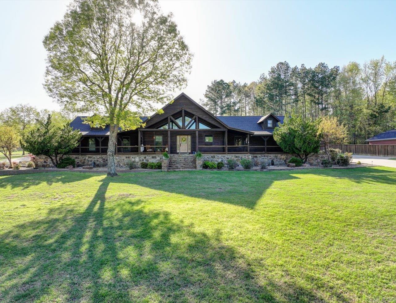 COLORADO-STYLE ESTATE ON HOLE 3 OF MALVERN COUNTRY CLUB - situated on 3+ acres with over 5407 SF of total living space! Main Home is ~3107 SF: Custom-built log cabin has 4 beds / 2 baths, a 3,000 SF wraparound porch, open layout, and fireplace with bedroom blowers. Master bath has 2 closets, soaking tub, walk-in shower, and 2 vanities. Pool House is ~1267 SF: Full kitchen, 3rd full bath, breakfast bar, wine fridge, stage, and a roll-up garage door to the pool area. Workshop/Game Room/Garage is ~1033 SF with a 4th full bath. Outdoor Living: 18x38 heated pool with new liner & robot, hot tub plus a 720 SF covered patio. Upgrades & Features: -Built-ins throughout -11 TVs (including pool house) -Wired security system -Starlink in attic -Brand new fridge & icemaker -Full bar -3 generators -Dog run -RV hookup -4-car carport -Smart home tech This home offers so much! Luxury, privacy, and deluxe amenities! COME AND SEE! Furnishings may be included with an acceptable offer. Agents - please schedule all showings with Showing Service.