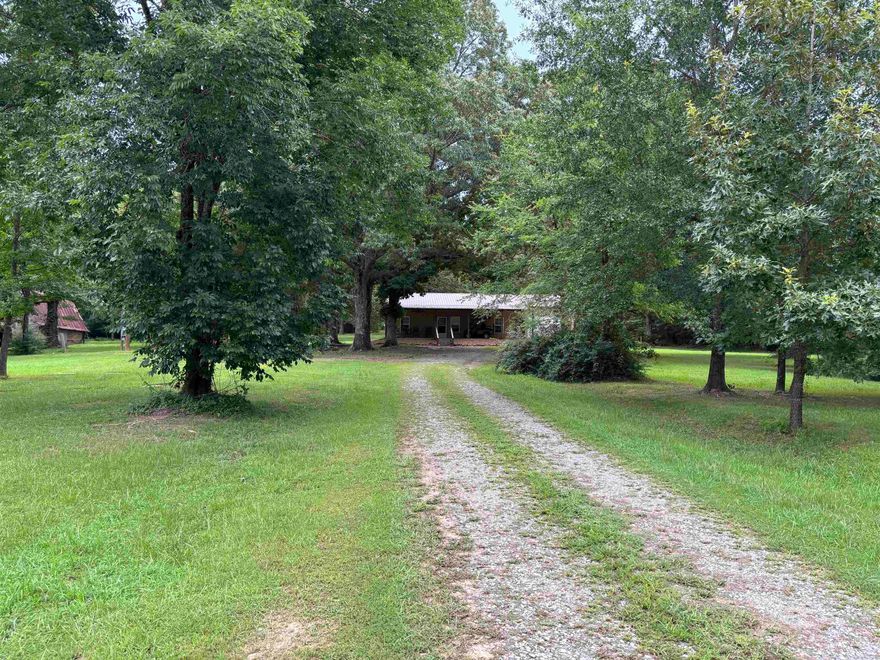 5+-acres.  2 Bed 2 full bath 1350 square foot metal home with concrete floors.  Large Bathrooms, large closets, One car garage all built on a slab.   Good Deer and Turkey are frequently seen on the property.   Very close to town, quiet, and secluded.  Well built home with a barn used for storage and a metal storage shed with concrete flooring.  City Water brand, new septic system, RV hook up, parking for dozens of vehicles.  Big tree Shaded yard.  Outstanding property to call home.