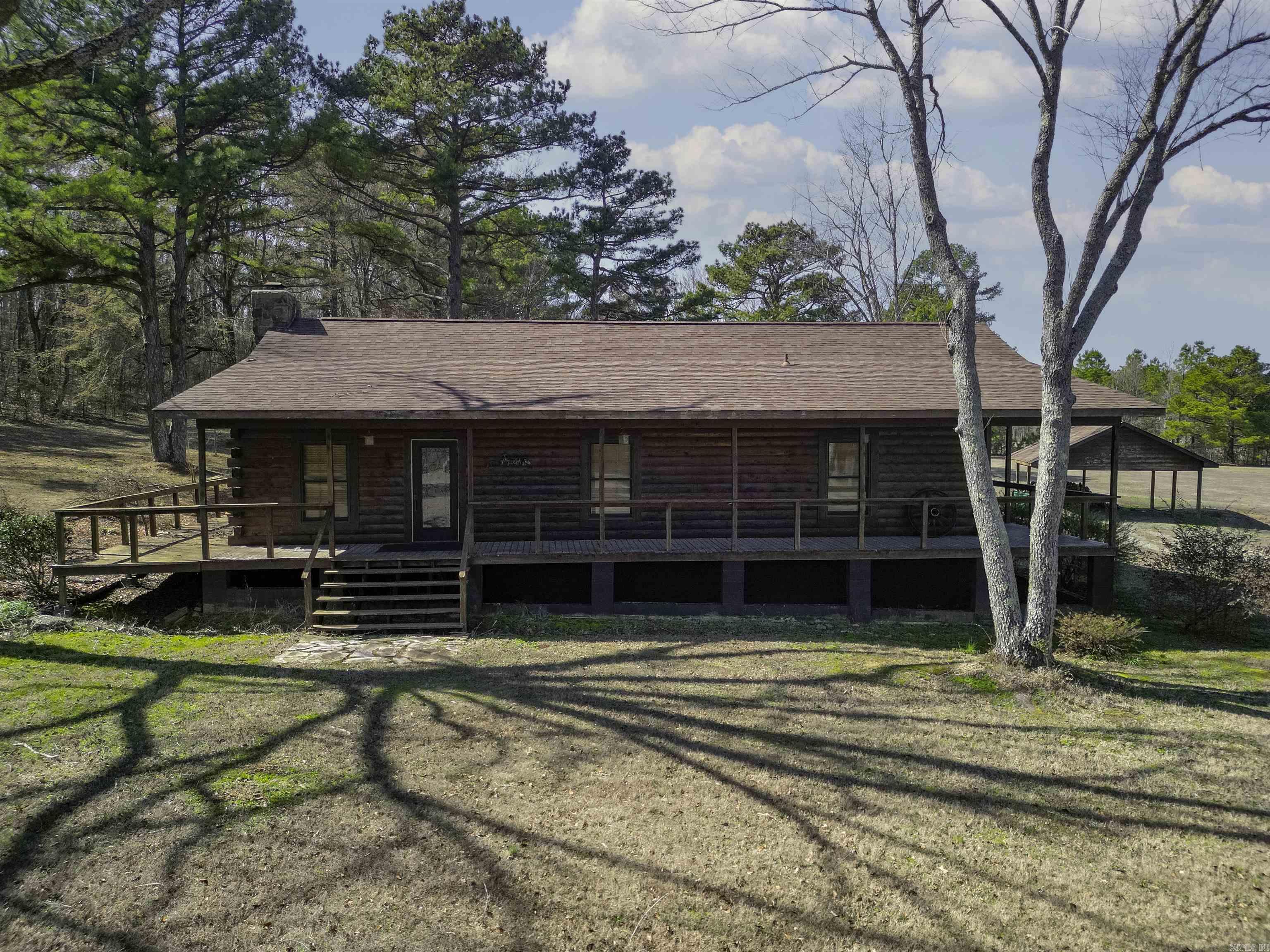 Cozy 3 bedroom 2 bath log home with wrap around porch, large living area with stone fireplace, stainless steel appliances, wood floors in living area, ceramic tile in wet areas, primary bedroom has a large walk-in closet, walk-in shower, barn with tack room, sitting on 7 acres!