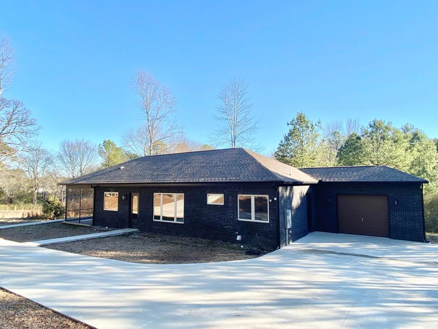 Welcome to 5501 Talley Rd – a charming retreat where modern comfort meets natural serenity. This home boasts a screened-in porch adorned with a wood-burning fireplace and a TV, creating the perfect haven for relaxation. Double pane windows and spray foam insulation for high energy efficiency.  The sleek concrete flooring flows seamlessly throughout, complementing the contemporary design. The kitchen features luxurious leathered granite countertops, adding a touch of elegance to your culinary endeavors. Situated on a private wooded acreage, this property offers a tranquil escape, inviting you to embrace the beauty of nature. Welcome home to a perfect blend of sophistication and seclusion.  Agents see remarks