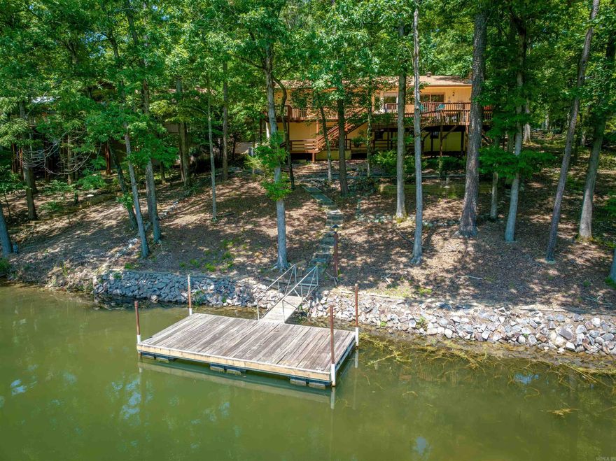 Lake Cortez WATERFRONT (full recreation lake - 240 acres) at an affordable price! 2Bedrooms/2Baths on the main floor and 1Bed/1Bath down + 500sq ft heated & cooled shop (included in sq ft)! Enjoy sunrises AND the cool shade in summer afternoons with East-facing view over the water and your own swim dock! Quality solid wood flooring, tray and coved ceilings, stone fireplace, and a remodeled walk-in shower in the primary bathroom w/walk-in closet! Bright tile kitchen, remodeled hall bath, skylight, and eating area open to the 2-tier entertainment sized deck! Roof was just inspected and in good shape! NEW $5k HEAT PUMP just installed! Hot Springs Village is 26,000 gated acres with 11 lakes and 9 golf courses, tennis, pickleball, miniature golf, bocce ball, dog park, archery range, indoor & outdoor pools, performing arts center, fitness center, 20+ miles of trails, and much more!!!