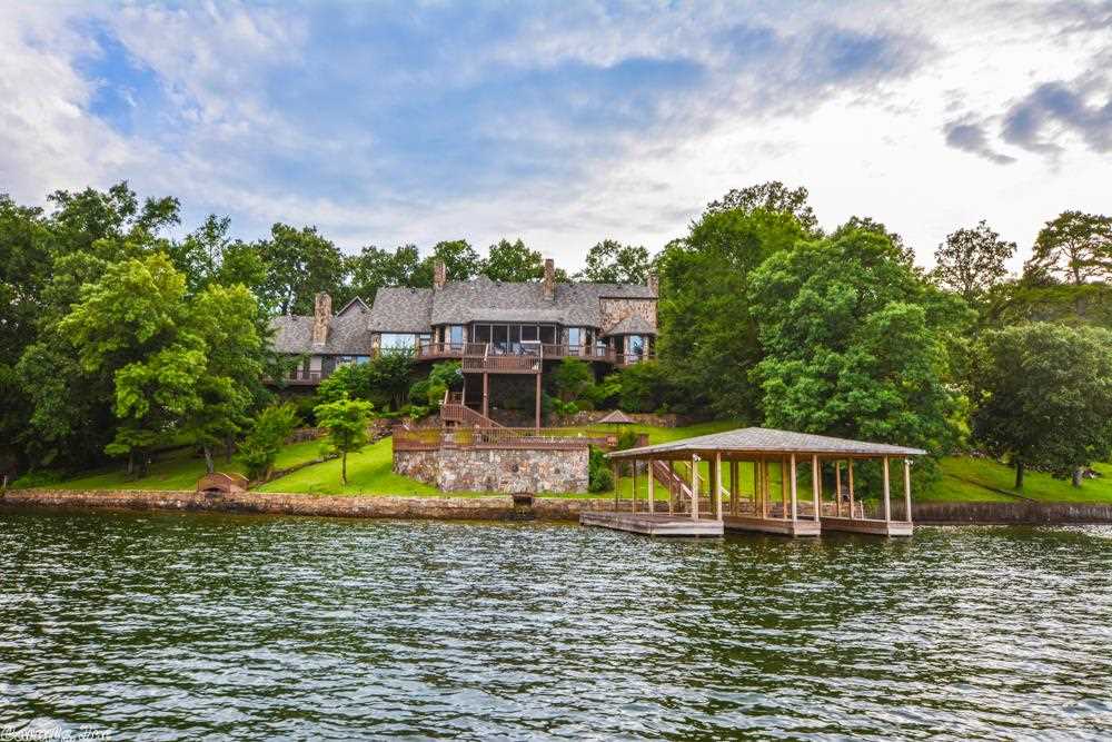 This magnificent trophy house perched on a superb estate site in Dogwood Haven is truly a home to be envied. Built to exacting specifications w/ almost no regard to cost, the home exudes quality in every inch of its 7,000 sf. Wait until you see the difference it makes when an architect has enough land to design a wide floorplan. The result is a free flowing house w/ lots of glass. It has everything including a pool, 5 fireplaces, garages for 4 cars, koi pond & the most magnificent main channel lake views!