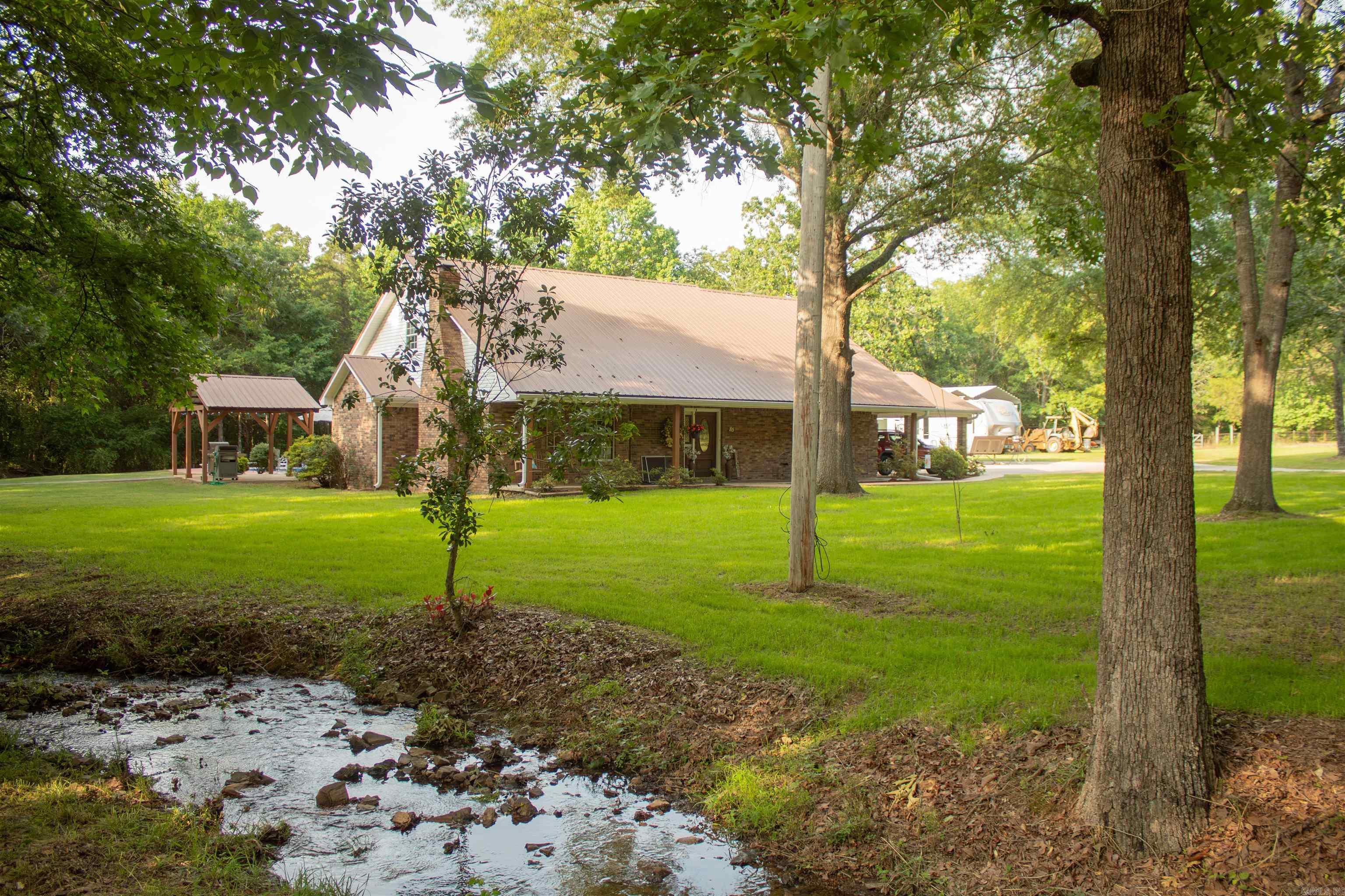 Beautiful 4 bedroom 3 bathroom brick home on 2 secluded acres with in ground Pool, Shop, Pergola and walk in Storm Shelter! Ideally located in the desirable Springhill Elementary School District, just minutes from town and only 15 minutes to I-40. This property offers the perfect blend of peaceful country living with a porch on the front and back of the home and plenty of mature shade trees around the property. Built in 1999 with recent updates such as: new LVP flooring throughout, new carpet in the downstairs primary bedroom and downstairs office/guest room and new epoxy countertops. Refrigerator, Washer and Dryer are 1.5 years old and all convey with the property. Whether you're looking for space to entertain, working on hobbies in the shop, or relaxing by the pool, this home has it all. Schedule your showing today and discover the best of country living close to town.