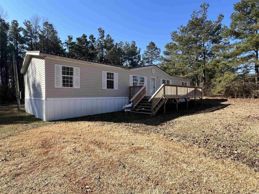 This 2002 Mobile home has been completely remodeled and is move in ready! New metal roof, floors, HVAC and paint. It has spacious bedrooms with large walk in closets, 2 living areas, woodburning fireplace with built-ins and 2 sets of French doors that lead to a 16x20 covered deck.  The kitchen has plenty of storage and counterspace and is open to Dining room and Den making entertaining a breeze! The Primary suite is separate from the guest rooms allowing for maximum privacy. Come enjoy the rural setting (3 acres) while being just 2 min from town. Pre-approval required for showing. Call us or your favorite Realtor!