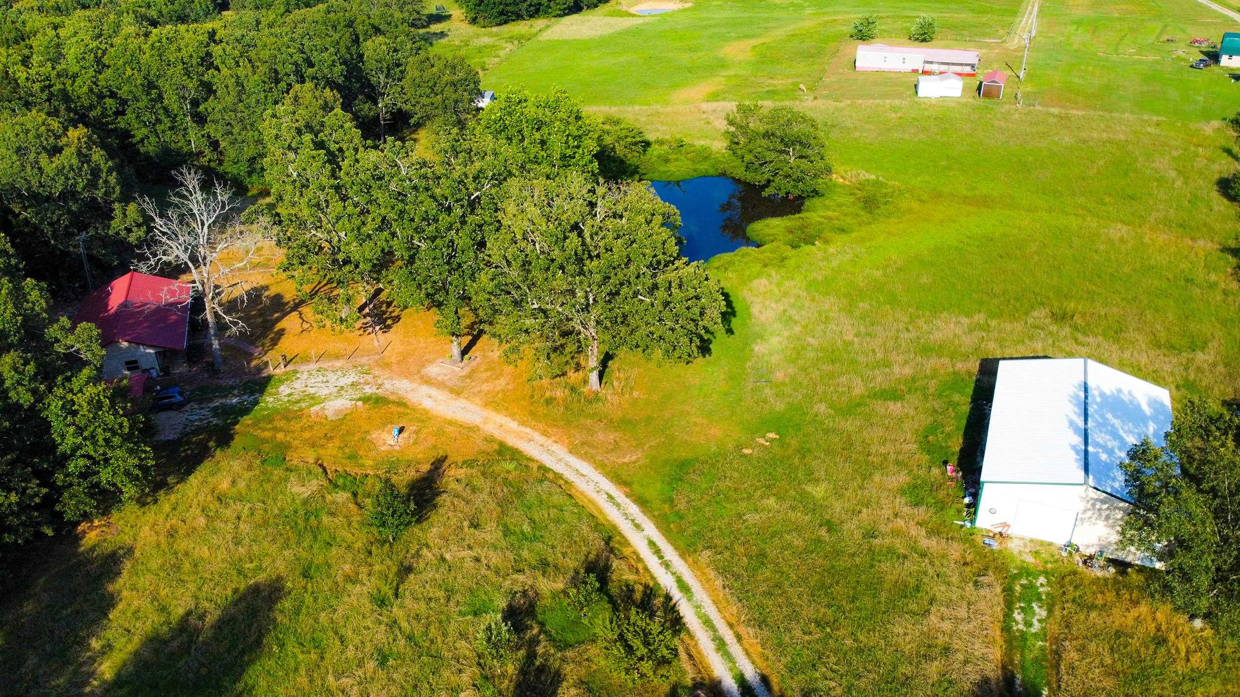 Discover 15 Acres of Pure Potential with this Property. Nestled just off the highway, this secluded gem offers a serene mix of pasture, timber, and its own private pond - ideal for peaceful living or future possibilities. At the heart of the property sits a cozy 1,150 sq. ft. home featuring 2 bedrooms and 2 baths, wrapped in a warm cabin-style ambiance. Whether you're starting fresh or looking for weekend retreat, it's ready to welcome you. A covered carport keeps your vehicles sheltered, while the 30 x 60 shop building - complete with electricity - opens the door to hobbies, or business ventures. Space to breathe, room to grow, and nature at your doorstep. Your dream escape awaits.