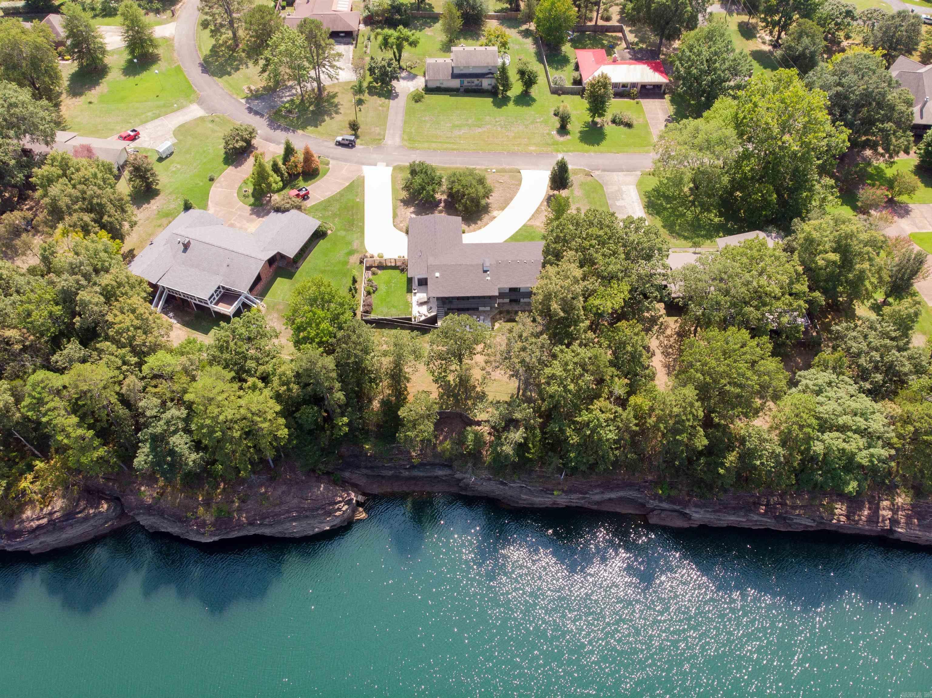 Lake front living at it's finest! This home sits on one of the best lake lots in town - level, close to the water with an open view and rare lake access. No boat necessary when you can walk out the back door and float in deep water. Enjoy lake views from nearly every room! 3 bedrooms, each with private bath and patio doors to the lakeside deck. The indoor/outdoor dining porch opens to the upper patio and is water side. Lower level has incredible views, a 2nd living area with Kitchenette, large guest room and full bath with shower. The house underwent an extensive renovation in 2020, taking the interior down to the studs and completely reconfiguring/rebuilding. Improvements include: all new wiring & plumbing, foam insulation, central vac, tankless water heater, custom cabinetry and upgraded finishes throughout. Home boasts a chef's kitchen with integrated Thermador Refrigerator & Freezer, Thermador 6 burner gas range, Bosch wall ovens and Fischer Paykel dishwasher drawers. The in town location is convenient to everything Heber has to offer, including all 3 marinas and the Little Red River. This is a unique lakefront property that won't last long!