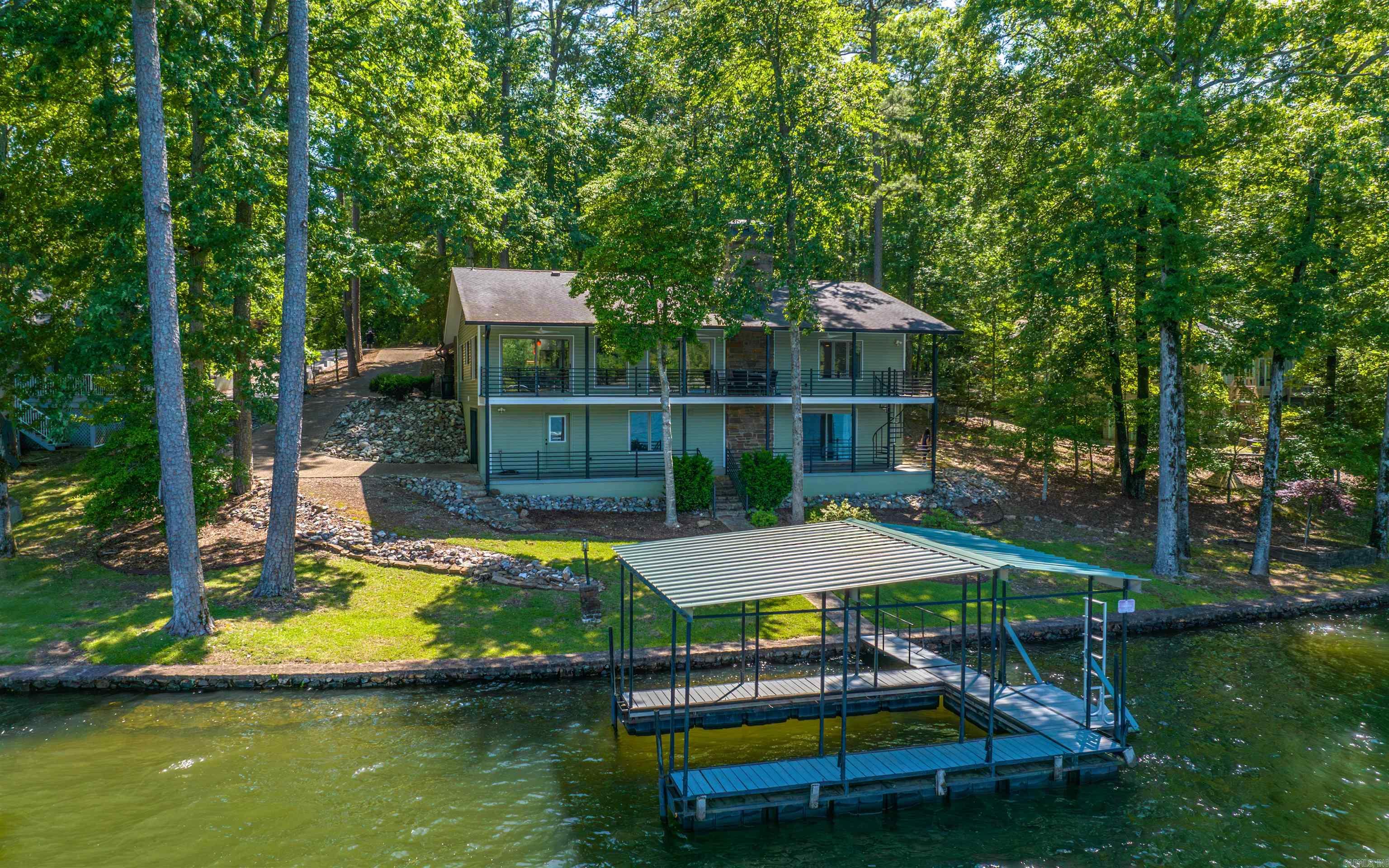 Discover this meticulously remodeled 4-bedroom, 3-full bath home with 160 feet of prime Lake Cortez frontage and expansive lake views, ideally located on a quiet cul-de-sac. Every detail has been thoughtfully updated in a mid-century modern minimalist style. Step inside to an entirely new interior, rebuilt from the studs. Luxury vinyl flooring flows throughout the main areas. The soundproofed TV room, featuring a solid door for sound reduction, offers a quiet escape. The kitchen updates include quartz countertops, all-new stainless-steel appliances, and custom cabinetry. All three bathrooms are brand new with custom cabinets. Comfort is ensured with a new HVAC heat pump. The downstairs offers a convenient apartment with a new kitchenette and a new split-unit HVAC. The exterior has a new roof, gutters, vinyl siding, fresh paint, and professional yard landscaping with new sprinklers and a lake pump. Enjoy the outdoors from a covered deck on the main level or the covered patio on the lower level. This property also includes a boat dock, a two-car carport, and a deep lower-level garage offering a workshop and loads of extra storage space.