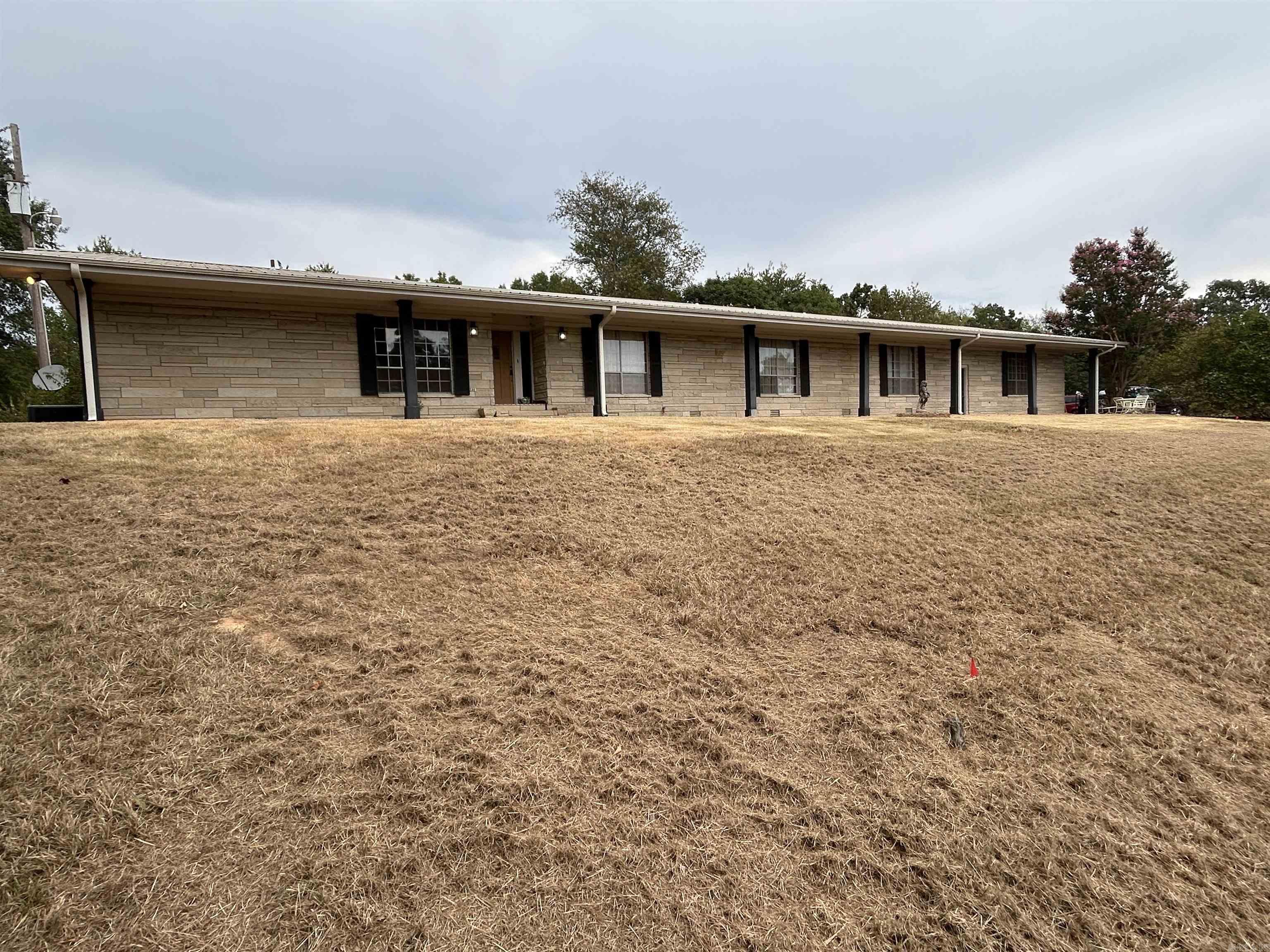 Large ledge stone ranch home sits on 8.59 acres with a spectacular view!! Long driveway off busy highway but only 3.5 miles to downtown Morrilton and 20 minutes to downtown Conway. Large kitchen with great potential! Large entertaining/kids room along with open great room off of kitchen. Full length sun room with hot tub, utility sink and space for lots of plants and projects. Whole house generator. Metal roof. Too much potential to mention it all!! Fenced in back yard for family pets and chicken coop ready for its new flock. Updating will be needed, flooring throughout required to be installed and master bathroom will need complete remodel. House will be sold "AS-IS, WHERE-IS" as price reflects. Can subdivide and sell lower portion of land and still have large beautiful yard with mature hardwoods and pines! *** Agents - please see remarks ***