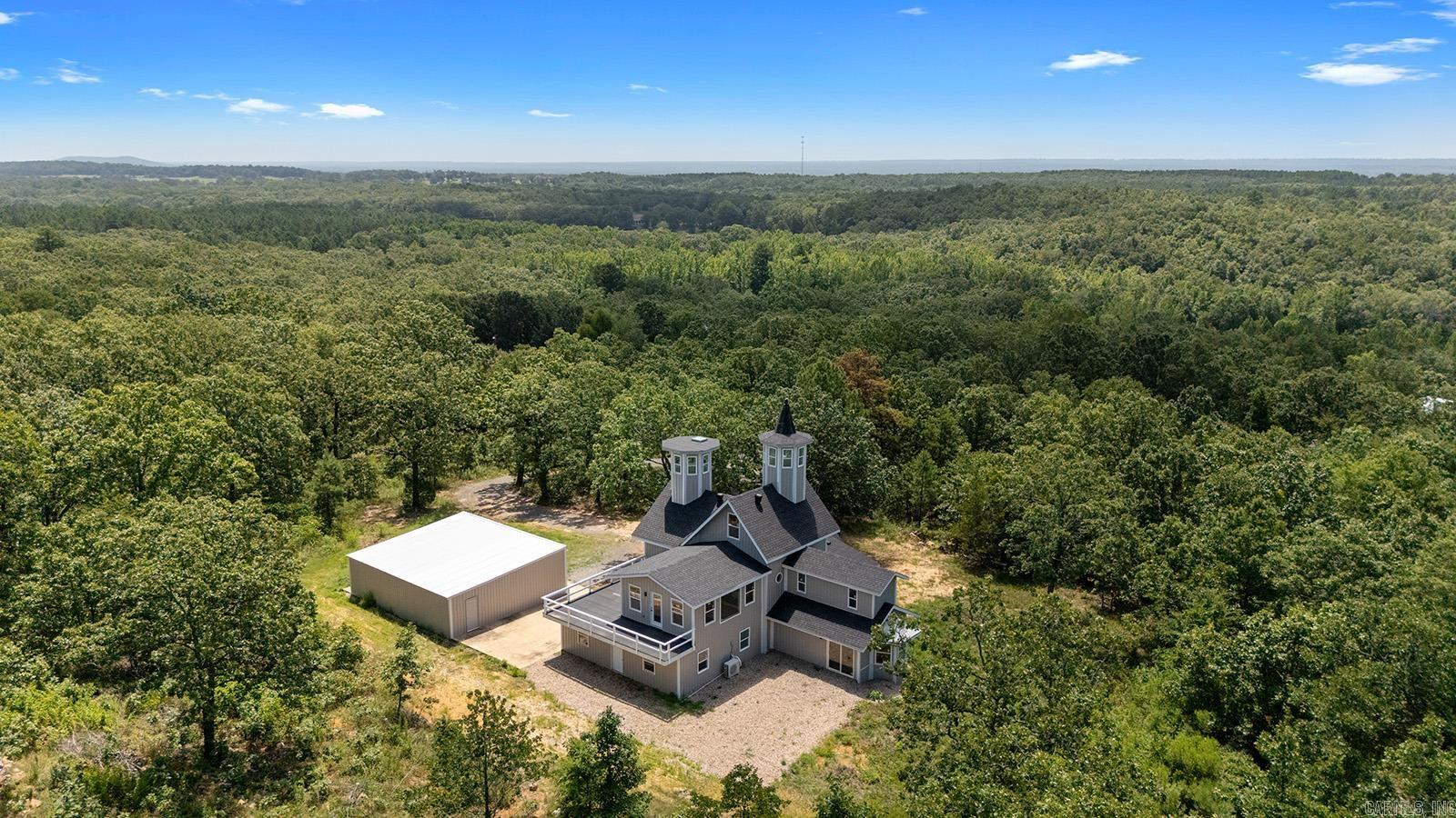 Truly one-of-a-kind, this stunning home features two castle-like spires and is perfect for kidsāyoung and old. The chefās kitchen boasts Calacatta quartz countertops and high-end stainless appliances. Enjoy the flexibility of two primary suitesāone on each level. Upstairs, the expansive primary bedroom offers abundant natural light and private access to a huge wraparound balcony. The luxurious en-suite bath includes a walk-in shower with bench and rainfall head, plus a soaking tub framed by bay windows. An extra room offers space for a home office or additional closet. On the third floor, a large playroom or childās bedroom leads to a magical spire lookout with wraparound windowsāperfect for sparking creativity. Nearly everything in this home is brand new, built from the ground up within the last year. Equipped with multi-zone high-efficiency heat pumps. A brand-new 1,080 sq ft shop is also included, with additional acreage available for purchase.