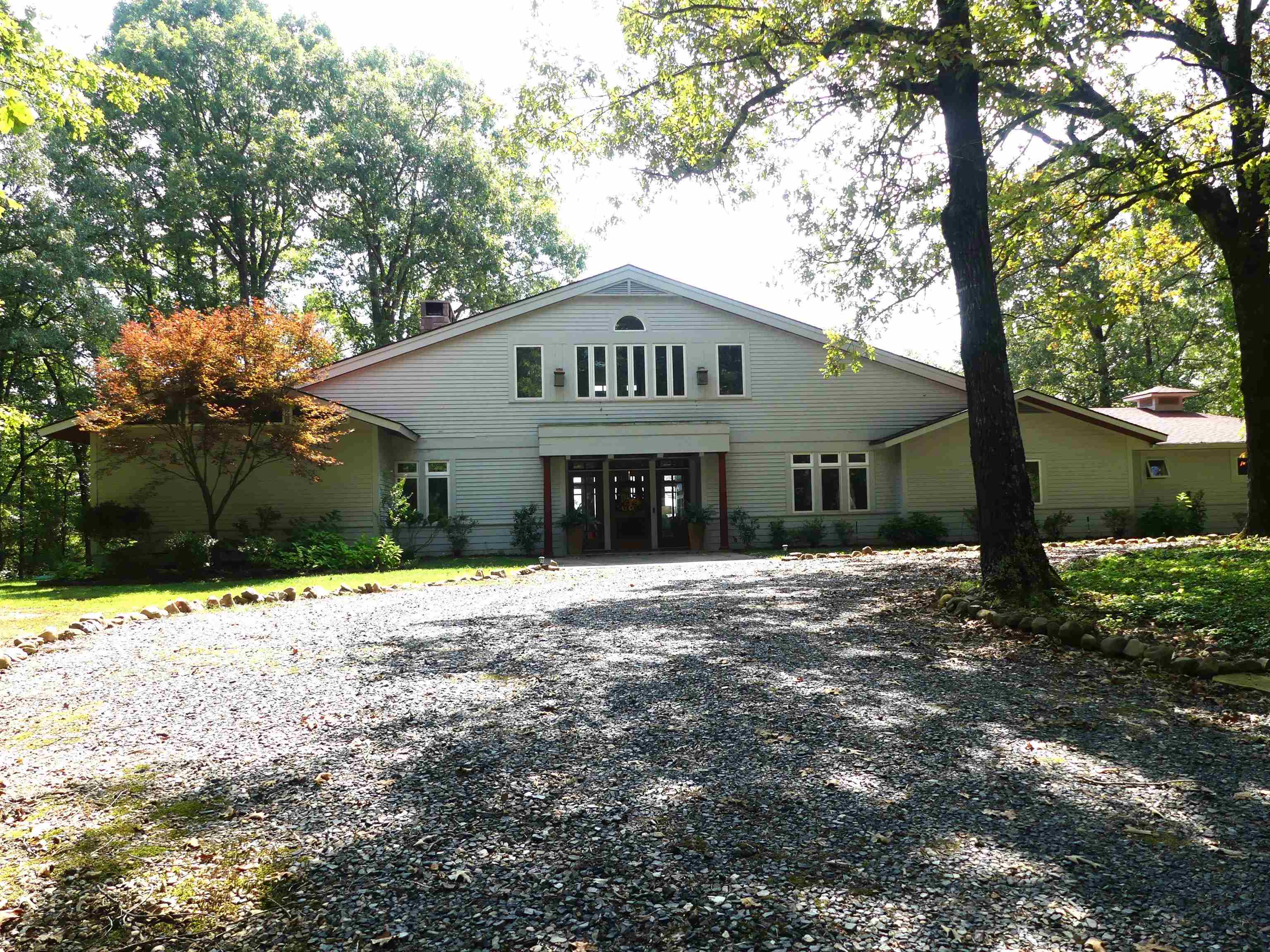 This mission style home is an architect designed, custom built home on 21 acres w/impressive mountain views that borders the Ouachita River. 5 bed/4 bath home features Amish Mennonite crafted oak hardwood doors & windows w/mixture of tile & oak flooring. Kitchen has 6 burner gas range w/double ovens, griddle, hood & warmers. Cabinets throughout kitchen are cherry w/glass inserts & Corian countertops. 2 dishwashers & 2 large pantries. Upstairs has primary suite w/balcony overlooking pool. Includes oversized double walk-in closets & shoe storage, bath includes double sinks, walk-in shower & jetted tub. 2 additional beds upstairs w/additional bath & walk-in closets. 2 beds on ground floor w/2 full baths, one handicap accessible. Living areas feature 2 wood burning stone fireplaces, one with country flame insert. Formal dining and breakfast nook with large bay windows. Attached oversized 2 car garage w/ additional storage. Detached 2 car garage/shop with woodshed beside. Ground sprinklers fed by well. Pool is 18' x 36' w/ cover and large concrete apron and composite deck. Also, whole home standby Generac generator.