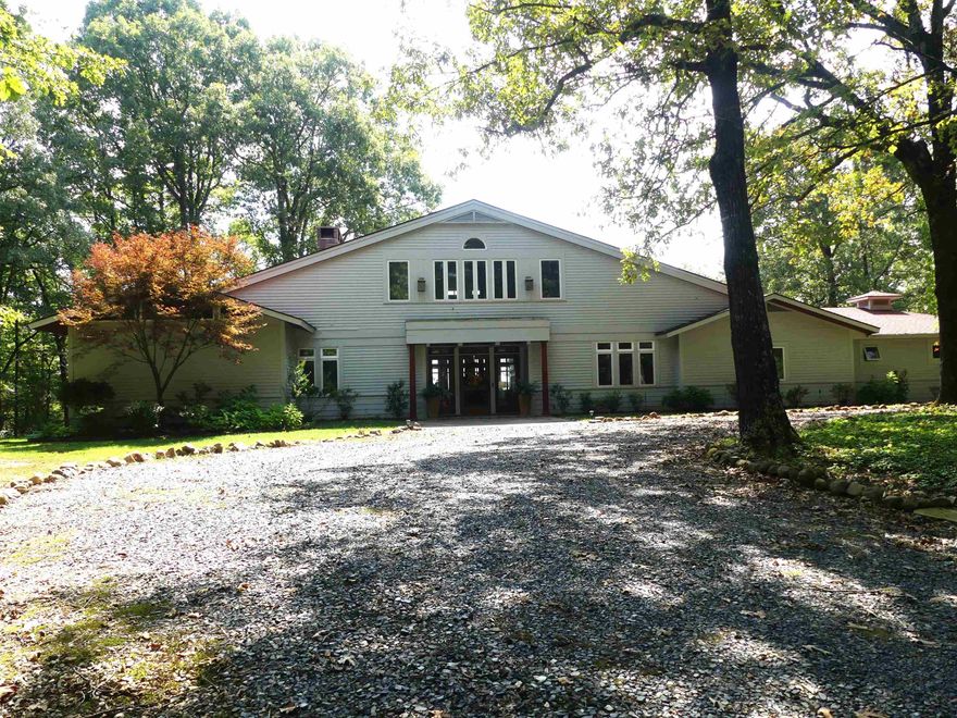 This mission style home is an architect designed, custom built home on 21 acres w/impressive mountain views that borders the Ouachita River.  5 bed/4 bath home features Amish Mennonite crafted oak hardwood doors & windows w/mixture of tile & oak flooring.  Kitchen has 6 burner gas range w/double ovens, griddle, hood & warmers.  Cabinets throughout kitchen are cherry w/glass inserts & Corian countertops. 2 dishwashers & 2 large pantries. Upstairs has primary suite w/balcony overlooking pool.  Includes oversized double walk-in closets & shoe storage, bath includes double sinks, walk-in shower & jetted tub.  2 additional beds upstairs w/additional bath & walk-in closets.  2 beds on ground floor w/2 full baths, one handicap accessible.  Living areas feature 2 wood burning stone fireplaces, one with country flame insert.  Formal dining and breakfast nook with large bay windows.  Attached oversized 2 car garage w/ additional storage. Detached 2 car garage/shop with woodshed beside.  Ground sprinklers fed by well.  Pool is 18' x 36' w/ cover and large concrete apron and composite deck.  Also, whole home standby Generac generator.