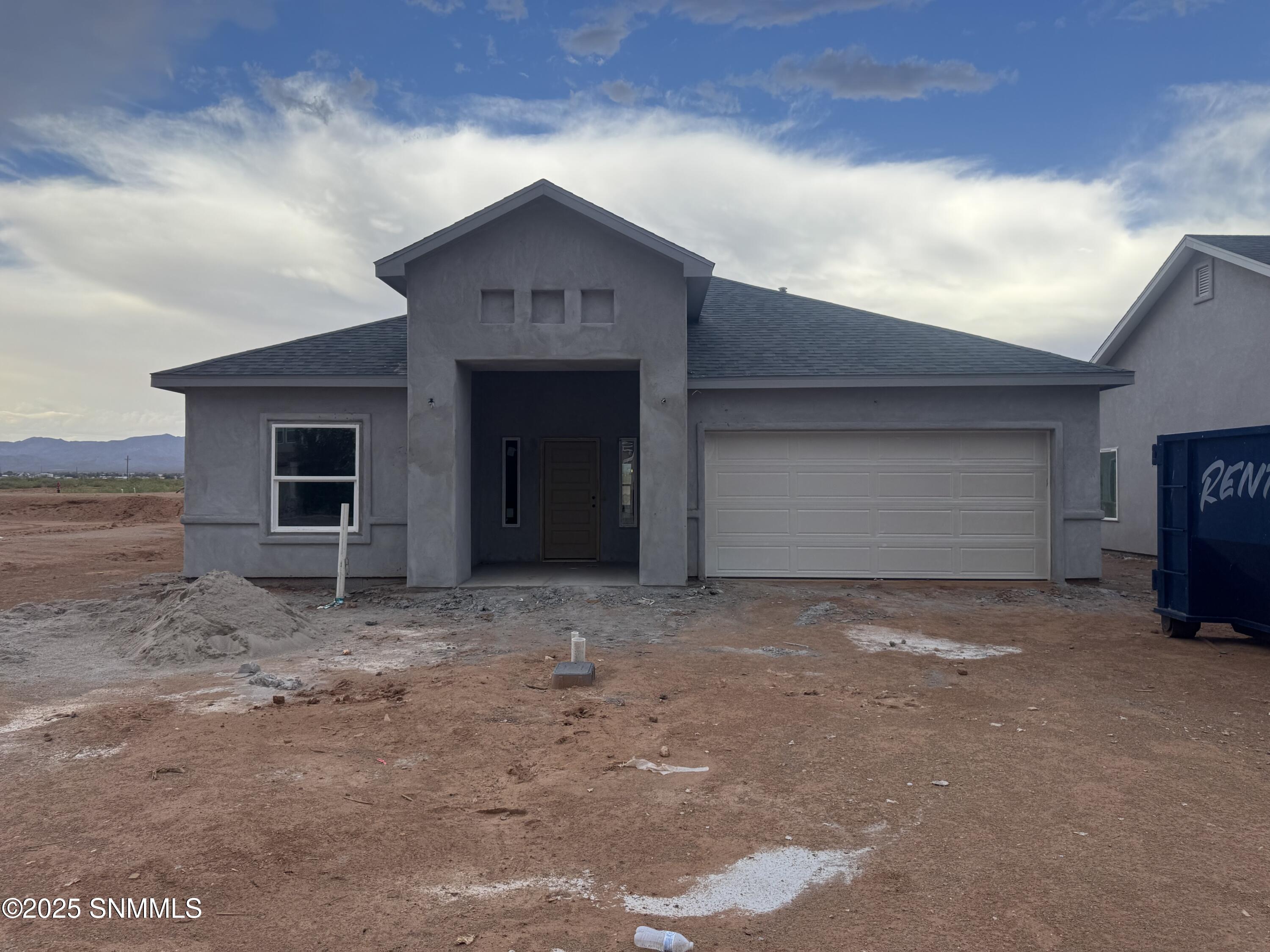 New construction home for sale in Las Cruces NM featuring modern desert-style architecture, xeriscape landscaping, and a spacious two-car garage.