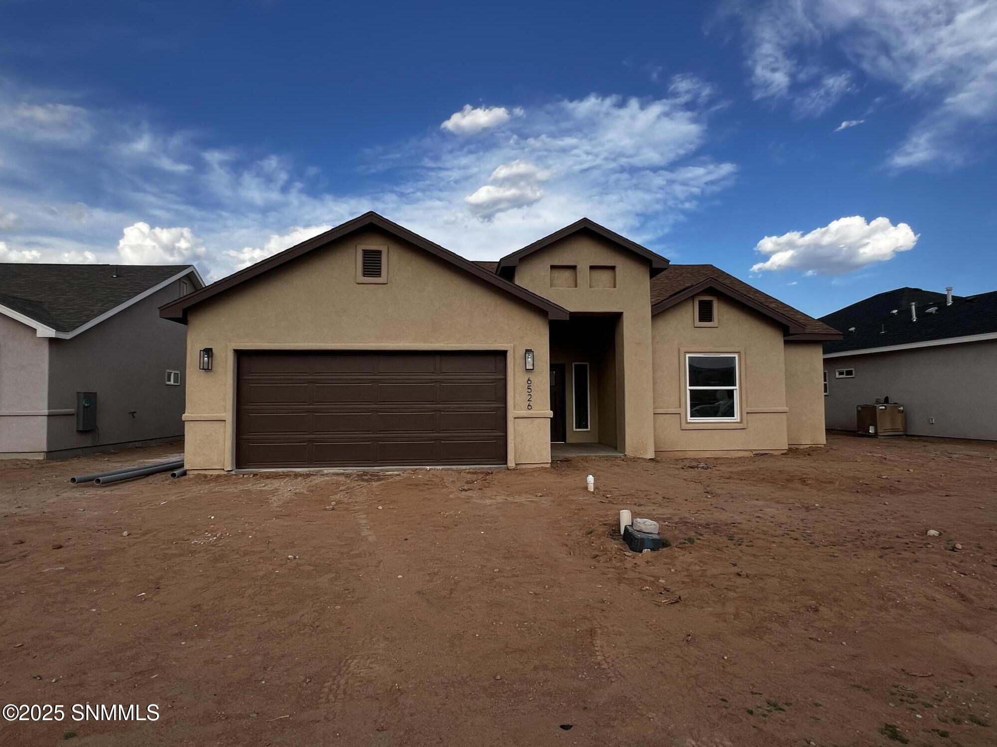 Spacious master bedroom with large windows, walk-in closet, and en-suite bathroom in a new build home in Las Cruces New Mexico.