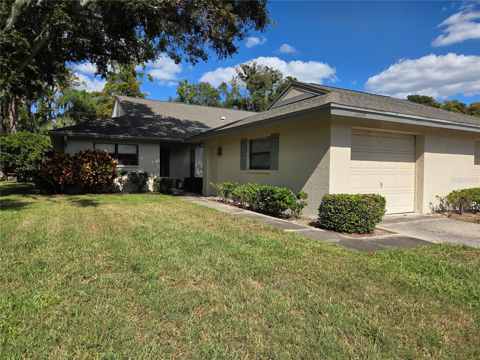 One or more photo(s) has been virtually staged. Great Opportunity. End unit villa with a garage and no rear neighbors in the wonderful Seven Springs Golf and Country Club community. The spacious kitchen with wood cabinets has room for a breakfast table and a snack bar. The lanai has a lovely view of the woods for privacy. The floor plan is open and spaciouse. The master bedroom has a large walk in closet and an ensuite bathroom which has a walk in shower and long double sink vanity. All living areas and bedrooms have lovely wood flooring. Some TLC will make this home yours in this beautiful country club community. Clubhouse has an active bar/restaurant/lounge, two pools for swimming and relaxing, tennis and pickleball courts. bocce ball, yoga, cycling and a championship and an executive golf course. Enjoy numerous dining and shopping establishments just down the road from the community gates. This is truly a home for carefree and maintenance free living.