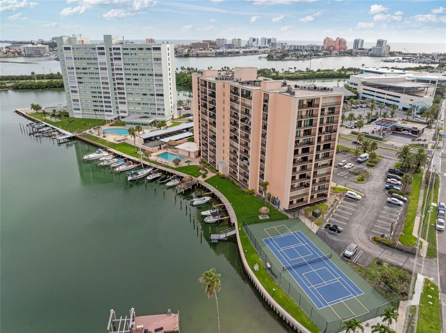 Experience true waterfront living in this beautifully updated 2-bedroom, 2-bath corner unit at 51 Island Way, Unit 411 in highly sought-after Island Estates—just minutes from Clearwater Beach. This renovated end-unit offers two private balconies and breathtaking water views of the Intracoastal, Gulf of Mexico, and Clearwater skyline. The interior has been redesigned with an open-concept floor plan, allowing natural light to flow through the hurricane-rated sliding glass doors. Updates include modern kitchen finishes, remodeled bathrooms, upgraded flooring, fresh paint, and new trim, creating a clean and timeless coastal feel. The primary suite features incredible water views, balcony access, a walk-in closet, and a beautifully remodeled ensuite bathroom with a walk-in rain shower. The spacious second bedroom also includes balcony access and views of the water, Island Estates, and the Clearwater Marine Aquarium. This resort-style waterfront community offers every amenity you could want: • Heated waterfront pool & spa • Tiki bar with large-screen TV • Tennis, pickleball & shuffleboard courts • Marina with boat slips (approx. $60/mo, first come) • Kayak launch & floating dock • Renovated saunas and locker rooms • Outdoor BBQ grills & waterfront seating areas • Secure keyless lobby entry, optional covered parking • Storage locker on same floor + laundry rooms on every level HOA includes: cable, high-speed internet, water, sewer, trash, building insurance, reserves, and on-site management. Unbeatable location—walk or take the Jolley Trolley to Clearwater Beach, Pier 60, top restaurants, shopping, and nightlife. You’re also steps from the Island Estates Publix, dining, banking, and local conveniences. Perfect for full-time coastal living or a low-maintenance beach retreat. Don't miss this rare waterfront corner unit in one of Clearwater’s premier condo communities. Schedule your private showing today!