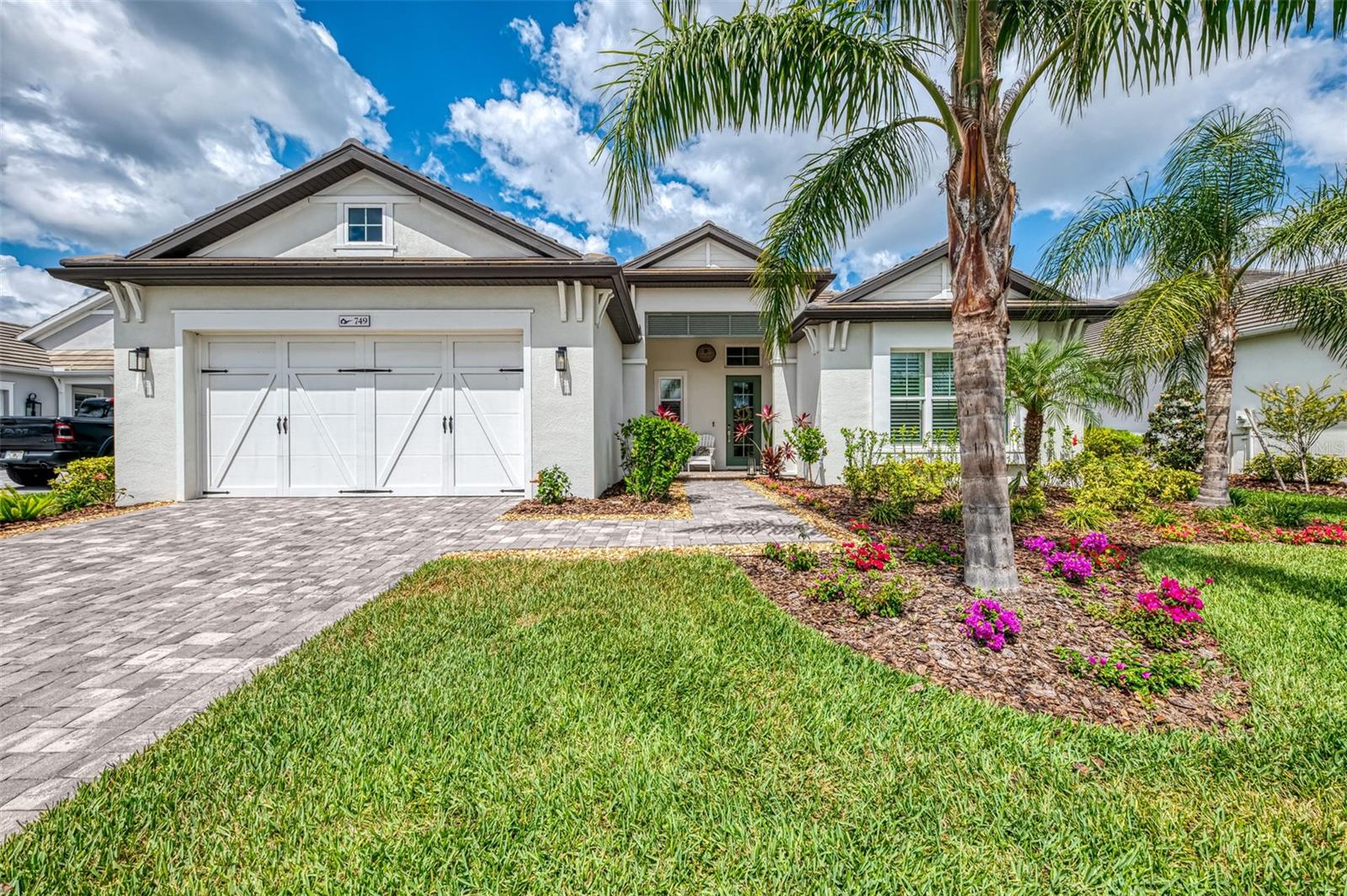 Discover the ultimate sanctuary at Lakehouse Cove, an exclusive waterfront enclave in Lakewood Ranch. This exquisite home, completed in 2022, spans over 3,100 square feet of single-level living, featuring four bedrooms plus a den, three full bathrooms, and contemporary finishes throughout an open-concept design. Step into the main living area, where a high vaulted ceiling adorned with decorative beams and a custom built-in display with lighted glass shelves and an electric fireplace create an inviting ambiance. The remarkable kitchen flows into the great room and boasts 22 feet of quartz counter space, a breakfast bar that seats six, a natural gas cooktop, a spacious center island with storage, and a walk-in pantry with electricity, a countertop for a coffee maker and toaster oven, storage drawers, and decorative backsplash. Adjacent to the kitchen is a custom dry bar, complete with a wine refrigerator, wine rack, and glass-front display cabinets. The smart split-bedroom layout ensures you and your guests privacy, with each bedroom offering a fully fitted walk-in closet and ceiling fan. Retreat to the tranquil owner's suite, where you'll find picturesque views of tropical landscape, a generous sized bedroom, a luxurious walk-in shower, dual vanities, and a private water closet. The expansive laundry room is well-appointed with a stylish backsplash, abundant storage, built-in cabinetry, a double closet, a wet sink, and a hanging rod. Enjoy numerous upgrades including a security system, plantation shutters, custom closets, beadboard, wainscoting, and garage shelving. The outdoor area is perfect for entertainment, featuring a saltwater heated pool and spa, an outdoor kitchen with a beer tap, and ample space for dining al fresco as you take in breathtaking sunsets. Safety and security are prioritized with hurricane-rated windows, doors, and an automatic whole-house Koehler generator. The three-car tandem garage includes easy-care epoxy flooring for added convenience. Lakehouse Cove provides residents with resort-style amenities, including a luxurious pool and spa, a state-of-the-art fitness center, social rooms, pickleball courts, fire pits, dog parks, and kayak storage at the boathouse, all offering glimpses of the stunning sunsets. Just a stone's throw away, Waterside Place offers fine shopping, dining, a weekly farmers market, and seasonal events, accessible via water taxi when available. Ideally located near University Town Center, Benderson Park, the Polo Grounds, and essential conveniences like hospitals, gas stations, and grocery stores, Lakehouse Cove is just south of University Parkway, granting easy access to downtown Sarasota, the airport, theaters, museums, and I-75. Seize the chance to embrace luxury living and exceptional convenience in this vibrant community. Make this remarkable home yours today!