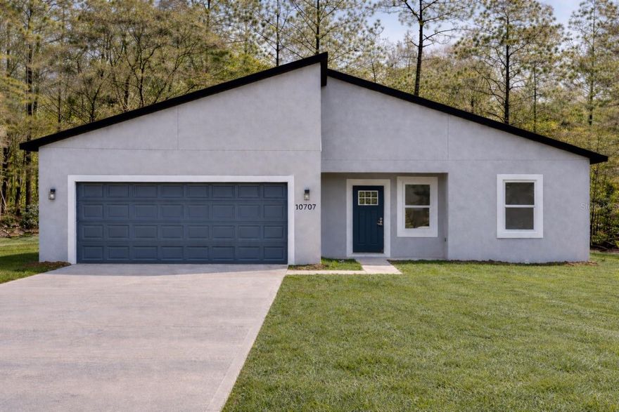 Modern new construction four-bedroom, two-bath home on a 0.23-acre lot in a quiet area of Dunnellon. This home offers an open-concept layout with a contemporary kitchen featuring white quartz countertops, shaker cabinetry, stainless steel appliances, and a spacious island ideal for everyday living and entertaining. The split-bedroom floor plan provides additional privacy, while the primary suite includes a walk-in closet and a beautifully finished bathroom with a quartz vanity and a tiled shower/tub combination, creating a clean and modern feel. Built with durable concrete block and stucco construction, the property also features a two-car garage and a large backyard with a patio, ideal for outdoor enjoyment. Conveniently near Rainbow Springs State Park, KP Hole Park and the Rainbow River.