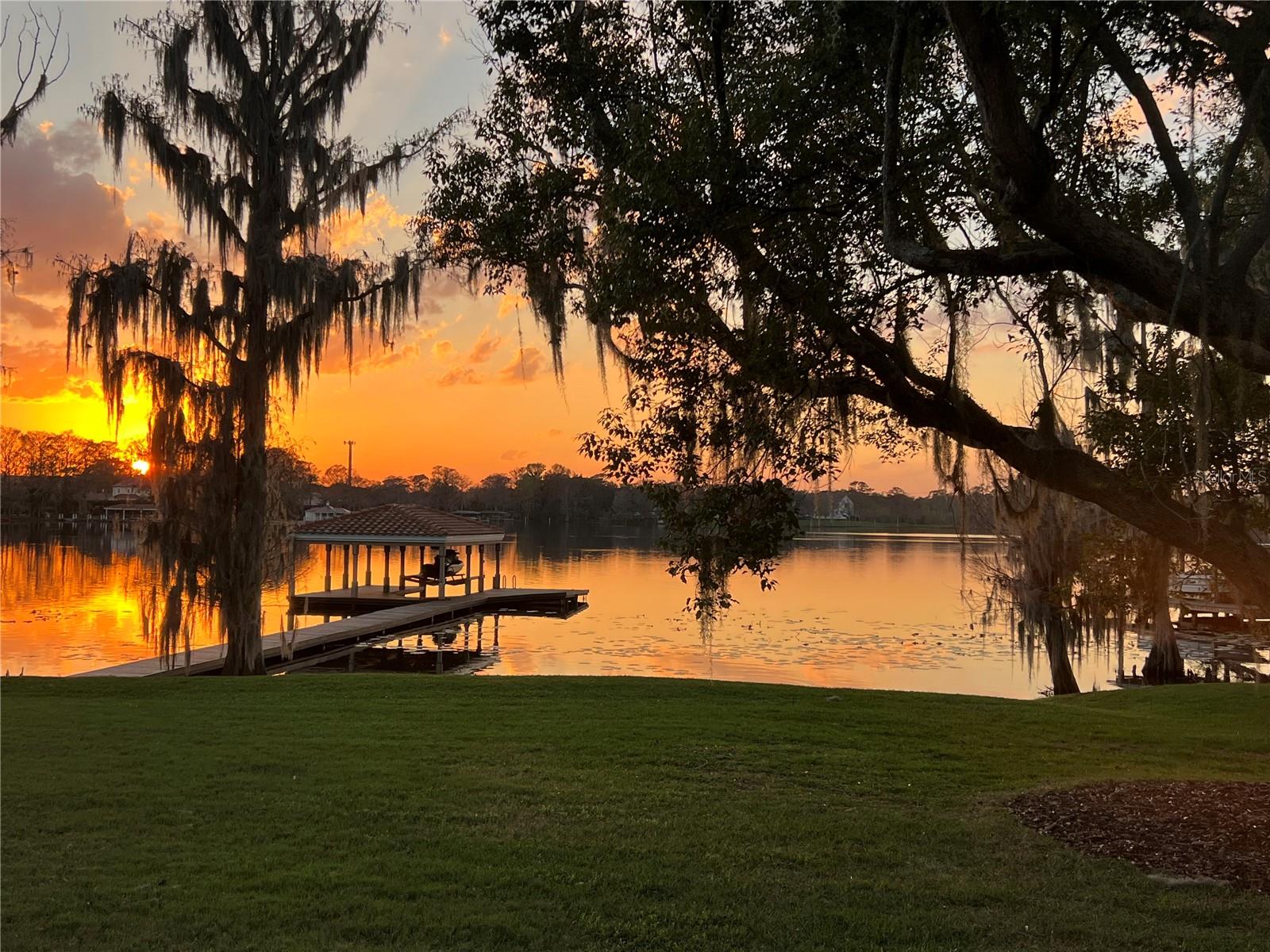One or more photo(s) has been virtually staged. Welcome to your private lakefront playground in the sought after Tuscawilla area where every day feels like a vacation! This one-of-a-kind estate sits on the shores of Lake Tuskawilla, perfect for boating, fishing, skiing, swimming, paddle boarding, or just floating the stress away. As an added plus, alligators have never been seen on this lake! And, the sunsets will melt your heart!
Drive through the beautifully landscaped entrance wall and brick-paved private drive to arrive at your quiet cul-de-sac escape, complete with a 3-car garage, beautiful gardens, pool, sauna, boathouse, dock, and massive party-ready deck. The inside? Even better.
With 5 bedrooms, 3.5 baths, and a separate 1-bedroom 1 bath guest house, there’s room for everyone! Soaring ceilings, an open layout, and floor-to-ceiling windows showcase breathtaking lake views. The chef’s kitchen boasts top-of-the-line appliances, an oversized island, and leathered quartzite countertops, while the adjoining wine bar features a custom 50-bottle rack and dual beverage fridges. The spacious living areas center around a dramatic three-sided wood-burning fireplace, perfect for entertaining.
The primary suite is pure indulgence—think cozy fireplace, spa-inspired bathroom, and custom closets that might require a shopping spree to fill. There’s even a large home gym with a private porch overlooking the lake which could be another guest room, home office or media room.
Step outside to your personal resort: a covered lanai, one-of-a-kind pool with a waterfall and a private sauna for the ultimate wind-down. Top it all off with a new tile roof and an upgraded oversized 3 car garage with epoxy floors and storage galore.
In addition, your offspring will enjoy the best education with the notable Geneva School just down the street as well as highly rated public schools. Golfers, tennis buffs and social butterflies will enjoy the Tuscawilla Country Club which is a stone's throw away. Parks, trails, restaurants and shopping are all conveniently situated in the community. Also commuting is a breeze with major highways nearby.
This isn’t just a home—it’s a lifestyle. If you’ve been dreaming of lakefront luxury with a twist of wow, your dream just docked.