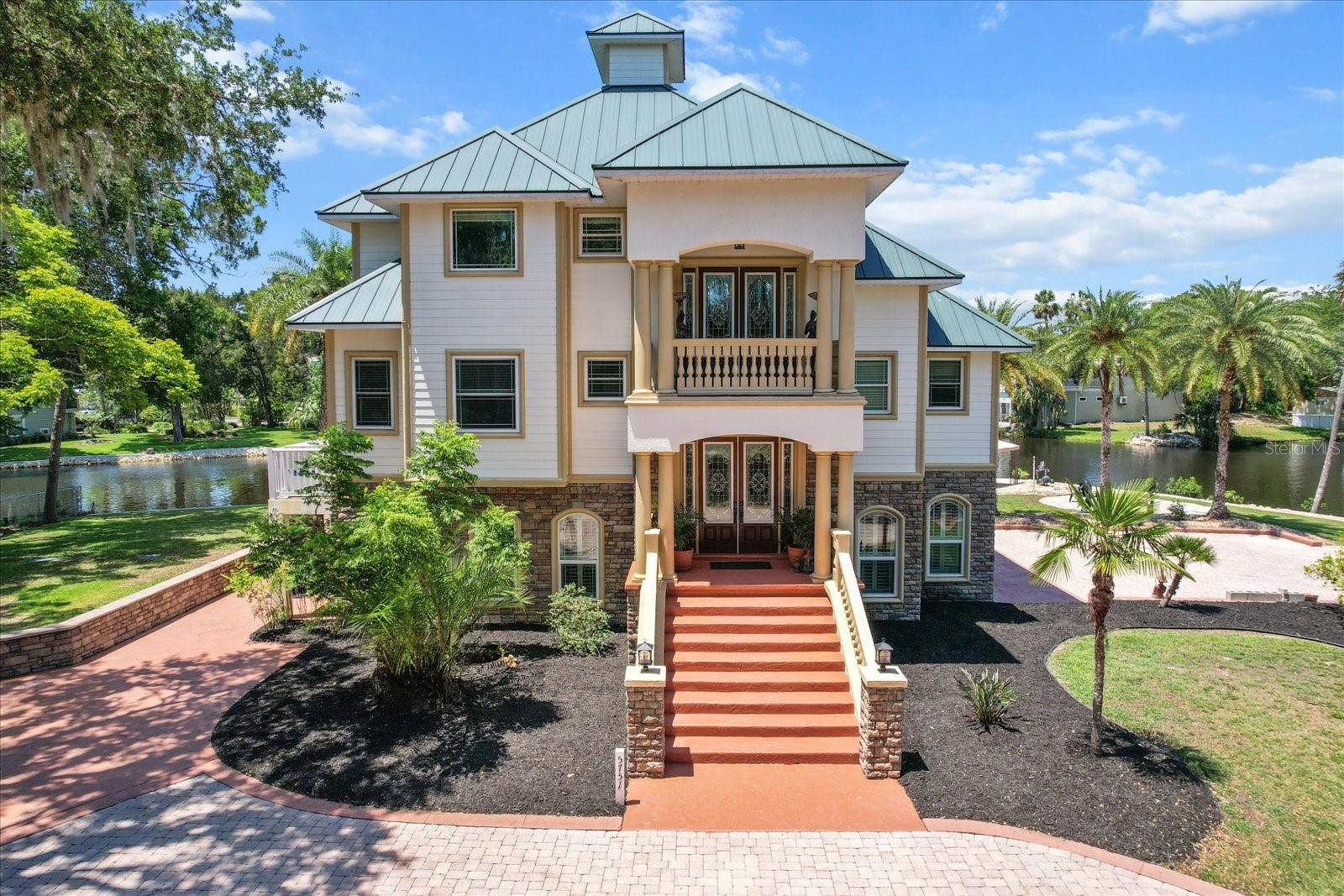 ARE YOU READY TO EXPERIENCE THE PINNACLE OF WATERFRONT REAL ESTATE? Here's your opportunity to indulge in Citrus County's elite custom-built 2008, 3-story waterfront home that sits on a .65 acre lot and boasts an impressive 230 feet of water frontage. Making it a true standout, the property is located on one of the widest, deepest canals the area has to offer. Built on reinforced pilings & privately tucked behind an electronic gate, the exterior exudes both luxury and durability- featuring a custom metal roof, whole house generator, an aerobic septic system & tankless propane water heater. Enjoy direct Gulf & Main River access from your private 30' boat house equipped with two 10,000 lb. boat lifts. Two Weardeck docks flank the impressive boathouse and provide ample space for relaxing. Additional outdoor features include a detached 16' x 18' garage, an RV parking pad (with 50 amp hookup), outdoor fire pit, and gazebo—perfect for entertaining or unwinding after a day on the water. The home’s inviting entryway features wide, welcoming steps & an elegant Juliet balcony that exemplifies refinement. Inside, step into soaring ceilings, wood flooring & doors, large windows & double doors that invite natural light & sprawling views. Fall in love with the custom kitchen's stainless steel appliances, granite countertops, 6-burner gas range, handcrafted cabinetry, & designer lighting. The 3rd-floor primary captures one of the best views in the home with spacious walk-in closet and a luxurious en-suite bath complete with a dreamy clawfoot tub—truly a retreat fit for royalty. The ground level includes a 2-car garage, room for entertaining and a flex space that is home to two separate bedrooms & a full bathroom. Under air this area is a great opportunity for a home gym, mother-in-law suite or additional storage space for all your toys! This golf-cart community is minutes from the area's many bars & restaurants. With no HOA or Deed Restrictions this property can be rented. Schedule your private tour of this stunning home today!