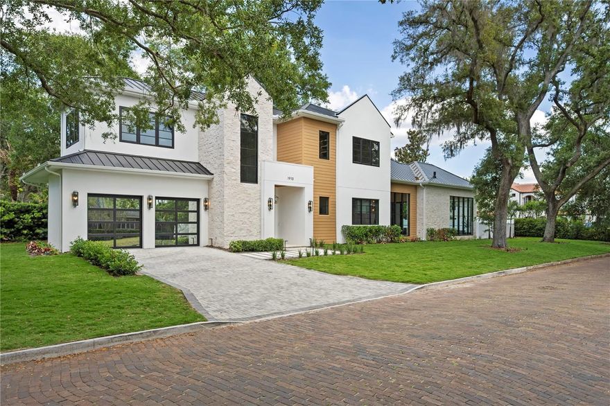 2026 PARADE OF HOMES ENTRY! - Positioned on an expansive corner lot in the heart of Winter Park, this extraordinary new masterpiece is a true architectural statement, delivering a level of craftsmanship and detail that is simply unforgettable. Framed by a massive front yard and a canopy of mature trees, the bold modern façade creates an immediate sense of arrival and sets the tone for what lies within. A grand set of double doors opens to a breathtaking two-story entry, where a dramatic marble mosaic feature establishes the home’s elevated design from the moment you step inside. The main living space is nothing short of stunning, anchored by a sleek electric fireplace and custom built-ins with integrated LED underlighting. At the heart of the home, the chef’s kitchen is a true showpiece, outfitted with Dekton Cosentino countertops, a paneled refrigerator, a full suite of Thermador appliances, and a hidden walk-in pantry. The kitchen flows effortlessly into the dining room which is bathed in natural light from an oversized statement window, making it perfect for hosting at any scale. Designed with versatility and luxury in mind, the home features two primary suites, one on each level. The downstairs primary offers soaring 12-foot ceilings and a serene, spa-like bath wrapped in marble mosaic tile. Upstairs, the main primary suite is a true showstopper, defined by its scale and attention to detail. Dual custom closet systems include an expansive hers closet complete with a dedicated makeup vanity, while the bathroom delivers a resort-caliber experience with stunning marble floors, a freestanding soaking tub, and dual vanities. The upper level continues to impress with a spacious loft designed for both relaxation and entertaining, complete with a custom entertainment center, wet bar, wine fridge, and a full bath. Each additional bedroom is ensuite, offering privacy and comfort for family and guests alike. Outdoor living rivals that of a private resort. A massive covered lanai features a fully equipped summer kitchen with tile backsplash, overlooking an expansive lounging area framed by a wall of glass. The heated pool and spa create the ultimate setting for year-round enjoyment, while the oversized front yard (an incredibly rare find in Winter Park), adds an unmatched sense of space and setting rarely found in this market. Additional features further elevate the home, including a sleek metal roof, striking hex LED lighting in the garage, and curated designer lighting fixtures throughout. Perfectly positioned just moments from Lake Chelton and Virginia Heights Park, with easy access to the boutiques and dining of Park Avenue and the charm of Hannibal Square, this residence offers a lifestyle that is as elevated as the home itself.