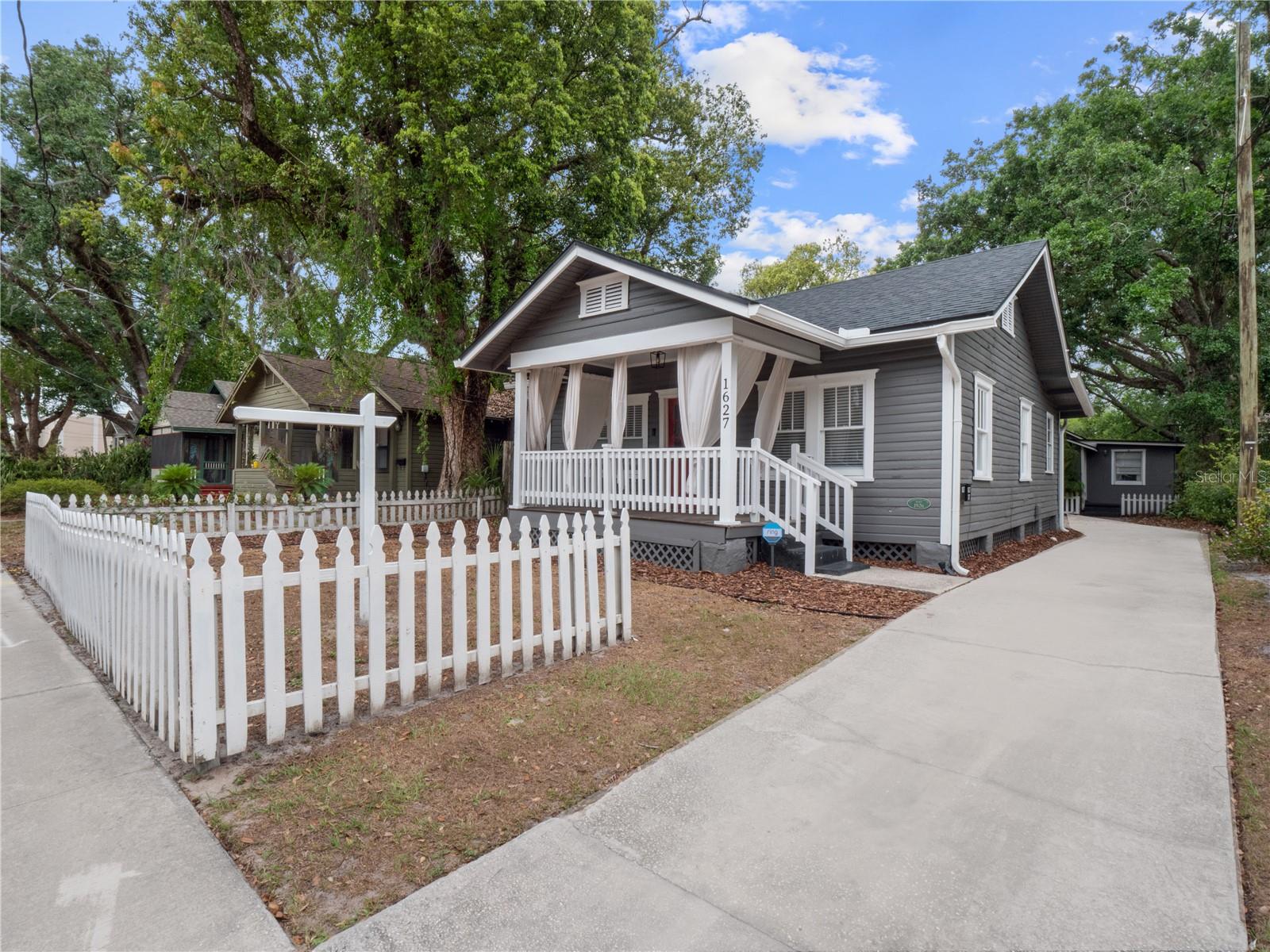 One or more photo(s) has been virtually staged. Charming 1920s Historic Bungalow available for rent just minutes from Downtown Orlando, Thornton Park, and Colonial Town! Step onto the cozy front porch, perfect for morning coffee or evening relaxation. Inside, you’ll find a spacious living room with a wood-burning fireplace with new tile and original hardwood floors that have been beautifully maintained. A formal dining area with built-in details and columns connects seamlessly to the kitchen. The kitchen is fully equipped with a 2024 gas stove, newer refrigerator, and 2024 dishwasher. Just off the kitchen is a convenient interior laundry room with exterior access to the backyard. The home features 3 bedrooms and 1 full bath with a porcelain pedestal sink and shower/tub combo. Key Features & Upgrades include smart locks, Nest thermostat, Ring security system (front doorbell & rear floodlight camera), and newer washer/dryer! With a 2014 roof, 2019 AC, 2023 water heater, and brand new 2024 plumbing, you’ll sleep soundly knowing this has been a very well taken care of property. This home offers a blend of historic charm and modern upgrades, ready for you to move in and enjoy.