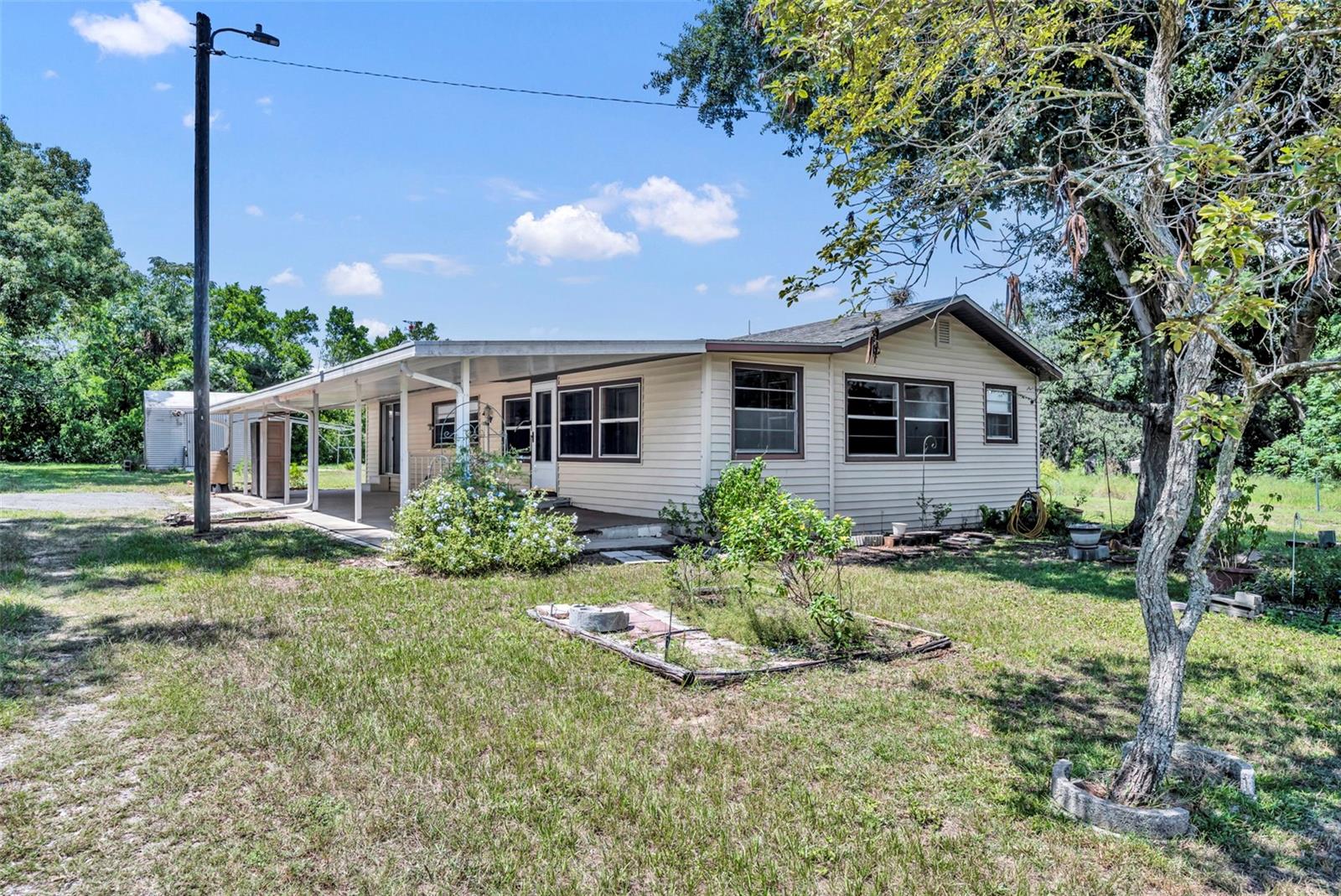 Charming 2-bedroom, 1-bath home with a versatile 12' x 12' den/office/bonus room which could also be used as a bedroom, offering 1,280 sq ft of comfortable living space at the end of a quiet and secluded dead-end street—just minutes from downtown Eustis and Mount Dora. This property includes the adjacent cleared .17-acre lot, giving you a combined 1/3 acre to enjoy. Inside, you’ll find a spacious 12' x 8' laundry room for added convenience and a pull-down ladder attic access. The home also features a 22' x 8' enclosed covered tiled porch, perfect for relaxing or entertaining, along with a 40' x 14' covered patio/carport for plenty of outdoor use and plenty of room to park your boat and RV. Two storage sheds (16' x 12' and 10' x 12') provide ample space for tools, hobbies, or extra storage. Major updates include a 2011 septic tank, 2021 drain field, and 2016 roof, giving peace of mind for years to come. A rare find with extra land, storage, and proximity to historic downtown charm—this one won’t last long!