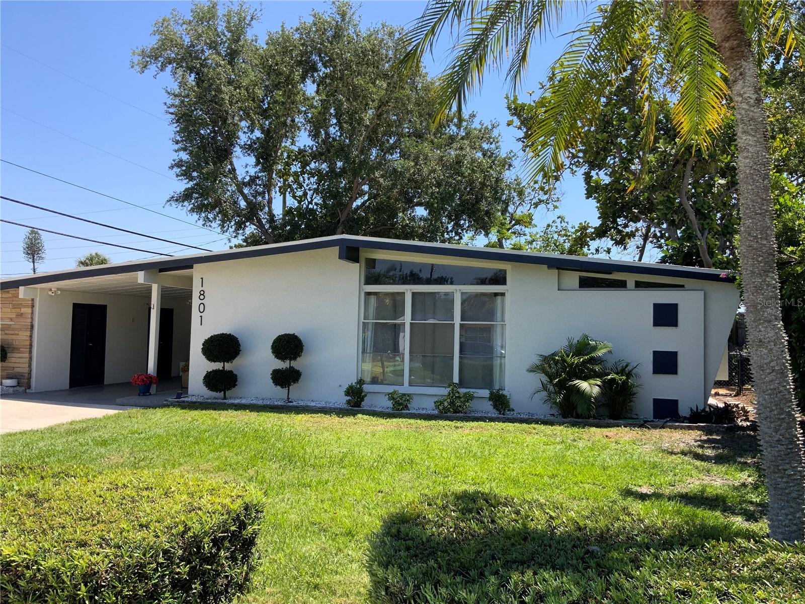 This home is an exceptional Mid-Century Modern Marvel built when homes were custom crafted with quality construction and appealing architecture, providing ambiance unlike the current Florida cookie cutter-style homes. If you are seeking a “wow” factor and uniqueness in style and décor, this is the home for you! Upon entering the home, you will immediately notice the light and bright open floor plan that includes a dining room with built-in hutch, an airy kitchen and large living room. The kitchen boasts white quartz countertops, shaker cabinets and island, making food preparation enjoyable. Pull out drawers were installed in the cabinets, and a pull-out trash receptacle cabinet was added. The pantry also has pull out drawers. Stainless steel appliances enhance the kitchen’s appeal. The breakfast bar is the perfect gathering spot to interact with the chef. The separate den/office/bonus room is off the living area and has direct access to the back yard. Storage and laundry are under the carport. This home features four bedrooms. The primary bedroom is located at the rear of the home, while Bedroom 2 across the hall is being used as a large walk-in closet for the primary suite. The third smaller bedroom serves as a guest bedroom and toy room/storage. The fourth bedroom, separate from the other bedrooms, is the largest, with its own mini-split a/c system, and set up as a teen suite with private entry. The Seller has spared no expense in remodeling their home. With a new a/c system, newer roof, refrigerator, stove (2025), luxury vinyl flooring, interior painting, remodel of the 4th bedroom, and updated primary bathroom, this house is truly “move-in ready”. There is also a new 12'x10' shed in the backyard. Enjoy your private, fenced, backyard with a fire pit for BBQs, entertainment, reading or friendly get-togethers. Added parking for boat/RV is available. Bayshore Gardens Park/Recreation Center is located on Sarasota Bay, offering residents access to the marina and private boat ramp. Boat slips are available, on a first-come, first-served basis at discounted rates. Additional amenities include boat and trailer storage, recreation hall, community junior Olympic-size swimming pool, ball fields, playground, grilling area, picnic pavilions, pickleball and basketball courts and kayak/canoe racks. A fishing pier and viewing area of Sarasota Bay add to the attractions of this waterfront community. Bayshore Gardens is conveniently located between downtown Bradenton and Sarasota, minutes from Sarasota-Bradenton International Airport, nearby IMG Sports Academy, the UTC Mall, Saint Armands Circle, Longboat Key and Anna Maria Island’s white sandy beaches. Also nearby are local shopping, eateries and entertainment for all. Do not miss the opportunity to own this stunning Mid-Century Modern home. Schedule your private showing today!