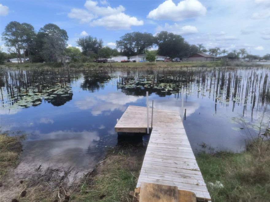 Lake front with floating dock. Huge backyard (0.5 acre lot). Sellers will install brand new shingles roof. Immerse yourself in the serene allure of lakefront living with this captivating property nestled in Central Florida. Discover tranquility and natural beauty right at your doorstep as you step into this affordable lakeside retreat. Embrace the essence of vacation living while embracing the pride of homeownership in this spacious abode. This inviting home boasts breathtaking views of the lake from key areas including the master bedroom, dining space, kitchen, and expansive screened patio. Delight in the vibrant array of wildlife that graces the lakeside, offering a constant connection to nature's wonders. Indulge your culinary senses in the stylish kitchen featuring chic grey shaker cabinets, a sleek glass backsplash, and modern stainless steel appliances including a glass cooktop. Ample closet space, including his and her closets in the master suite, ensures seamless organization and convenience. Luxuriate in the upgraded bathroom equipped with dual sinks, while the built-in study/work desks in the kitchen and family room cater to modern lifestyles. A convenient storage shed in the backyard adds practicality to this charming oasis. Experience outdoor living at its finest with the expansive 28 ft x 15 ft screened and covered patio, offering panoramic views of the tranquil lake. Don't miss out on the opportunity to make this picturesque retreat your own. No homeowners association and $0 HOA dues. This sale comes with an outdoor storage shed measuring 8ft x 8ft. Bedroom Closet Type: Built In Closet (Primary Bedroom).