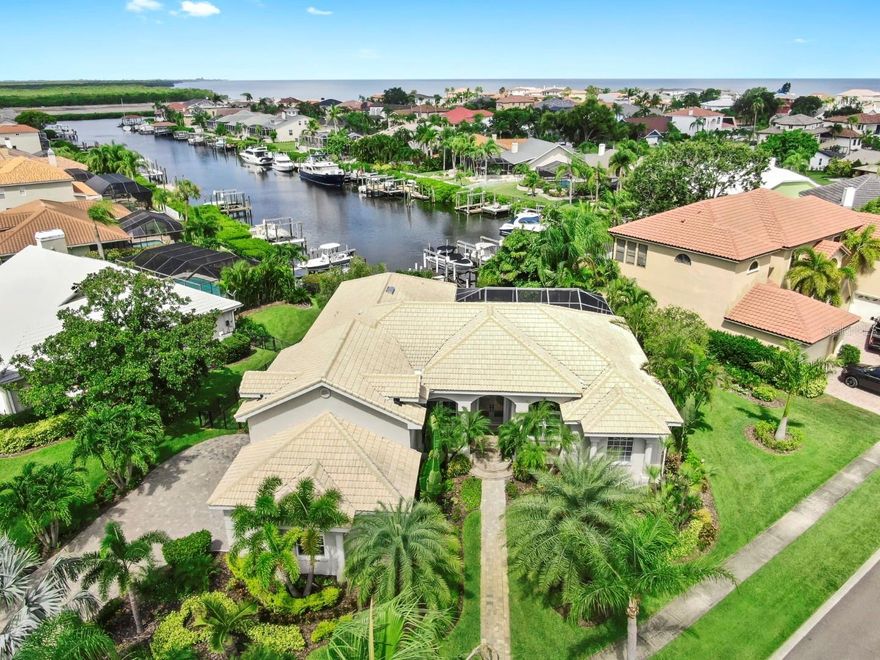Discover the epitome of elegance and sophistication in this meticulously crafted waterfront home nestled within the prestigious Symphony Isles community. Every detail has been thoughtfully selected and upgraded to create a seamless blend of luxury, comfort, and style. From the moment you arrive, you'll be captivated by the beautifully landscaped grounds, featuring lush, well-maintained greenery and a welcoming front porch with classic columns. The pavered driveway leads to a spacious side-entry garage, complemented by a grand double-door entrance that beckons you inside. Step into an expansive open floorplan accentuated by luxurious upgraded laminate flooring, soaring double tray ceilings, and large windows dressed with elegant plantation shutters that flood the space with natural light. Upgraded lighting fixtures add a touch of sophistication throughout. The chef's kitchen boasts imported granite countertops, high-end GE Profile appliances, and sleek white cabinets reaching to the ceiling with tasteful crown molding. The large island provides ample workspace and casual dining options, perfect for entertaining. Relax in the spacious family room featuring a stunning wood accent wall and an electric fireplace—ideal for cozy evenings. For cinephiles, the $35,000 home theater system with Custom high end home theater amplifiers delivers incredible sound throughout the house. This entire home is equipped with smart technology, allowing you to control lighting, the EcoV thermostat, music, and more via Alexa. With three new AC units and a garage mini-split system, you’ll enjoy optimal comfort year-round. The luxurious master suite offers breathtaking water views and direct pool access. It features triple tray ceilings, two large California closets, and a spa-like bathroom with a spacious shower and a standalone soaking tub—your private sanctuary. On the opposite side of the home, you'll find three generous guest bedrooms and two large bathrooms, including one with pool access. Upstairs, a versatile open space awaits—perfect for a media room, hobby area, or art studio. Step outside to your fully renovated saltwater pool and patio area, equipped with Web-Control Aqualink, new pool heater, and automatic pool refill system. New outdoor kitchen, with commercial grade hood, beverage refrigerator, and large bar and siting area! Enclosed with Noseeim screens and a fully fenced yard, this outdoor oasis is perfect for entertaining and relaxing. Enjoy your private dock featuring two electric boat lifts with water and electric hookups—ideal for boating enthusiasts. The Symphony Isles community offers 24/7 manned gated security, private roads, a pristine private beach, clubhouse, and a private boat ramp. Schedule your private tour today and experience this exceptional waterfront paradise in Symphony Isles!