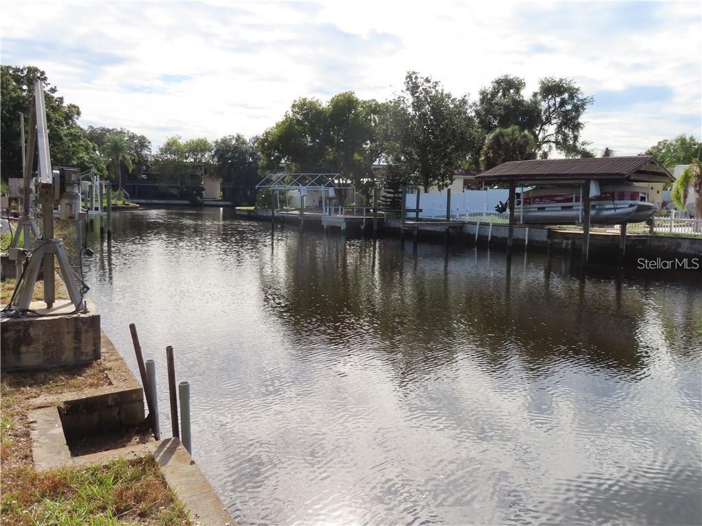 Welcome to your sanctuary of waterfront living in Tampa Town n Country 5818 Portsmouth Dr!
This well maintained, move-in ready manufactured home captures the essence of Florida charm with 4 bedrooms, 2 full baths, and 1,620 sq ft of thoughtfully designed living space, total space is 2716 with attached carport, storage area & waterfront screened room. Step inside to discover gleaming hardwood floors, crown moulding, and an open, airy layout that invites you to relax and entertain. The master suite offers luxury and privacy with its dual-entry closet and ensuite bath featuring both a garden tub and separate shower Three additional bedrooms with scenic canal views, and one of them opens to a covered, screened patio, new Air conditioner & Davits with new motors to lift your Boat, your personal outdoor oasis overlooking the tranquility of a saltwater canal. With boating access to Tampa Bay, every day at home feels like a vacation. Beyond your serene slice of waterfront bliss, daily life is effortless. A wealth of shopping from Publix, ALDI, Walmart Neighborhood market with in 1 mile Super target 2.5 miles super Walmart 5 miles TJ Max 3 miles Ross 1 mile Bravo 2 miles, just about any kind of restaurant you wish with in 5 miles do not miss the opportunity to make this home yours schedule a private showing today before it is gone