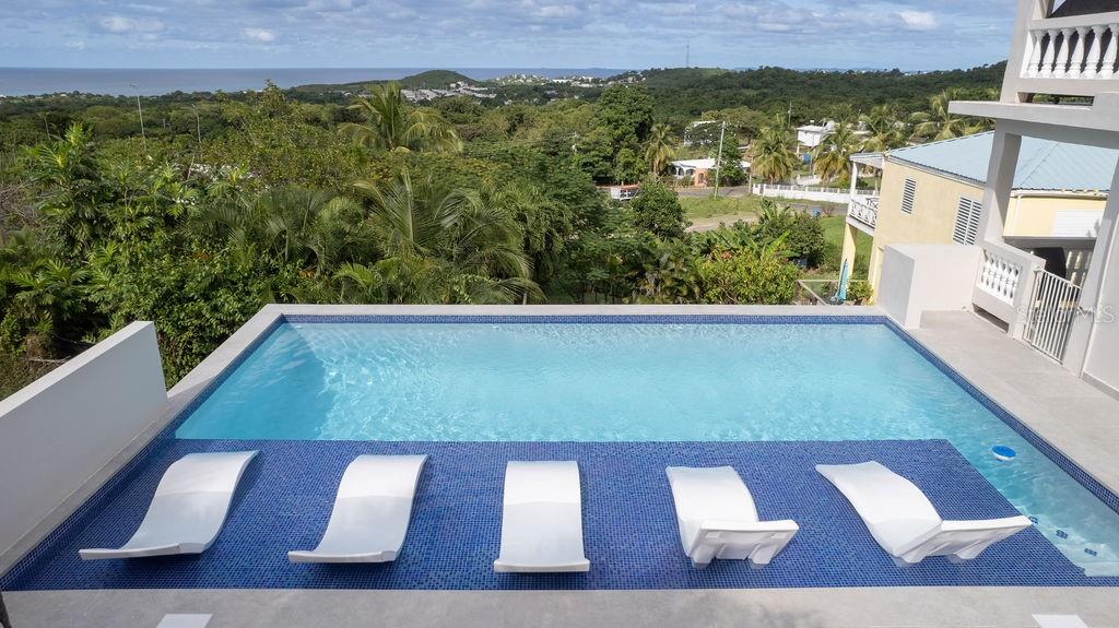 Mar Vista is nestled into the hillside in the Los Chivos neighborhood on Vieques Island and has extraordinary views of the North coast including Culebra Island and Cayo Blanco and the main island of Puerto Rico.
Mar Vista is a classic Caribbean style home with three bedrooms and two bathrooms on two levels and surrounded by lush tropical gardens and a stunning, new swimming pool.
Under new ownership many changes have been made including beautiful new bathroom renovations, , new windows, new mini-split air conditioners , new interior doors, new furniture, removal of trees to enhance the views and new equipment. This is a must see!
The top level has the primary bedroom and bathroom both being very spacious. The bathroom is newly renovated with beautiful concrete counters, white fixtures and contemporary tiles. The upper level with primary bedroom is the main gathering area with a large open concept living area featuring panoramic ocean views from inside as well as from the oversized wrap around balconies. The very large kitchen is functional and has white kitchen cabinets and beautiful granite counter tops. The cook top has six burners and is gas.
The middle level of the home is reached connected by a stairway and is completely self contained second unit. There are two guest rooms sharing an all newly renovated bathroom. The home has a generous open floor plan with kitchen, living room and dining area all sweeping out to large outdoor balconies. The pool is easily accessed through the back door of the home. There large storage area, craft room or shop on this level as well.
The lower level of the home features a laundry for the whole property and ample owner's storage space.
The home has secure off street parking and beautiful mature tropical landscaping. All three bedrooms have mini split air conditioning systems, security systems and the home is sold turn key furnished.
The home features a back up water cistern and a solar hot water heater and an electric back-up generator.
Mar Vista is surrounded by tropical gardens that will delight you. There are beautiful palm trees, succulents, colorful Bougainvillea and Heliconia, ferns and many other delights.