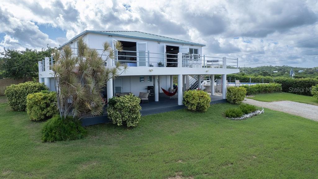 This recently constructed home offers a peaceful retreat with panoramic ocean vistas stretching toward Culebra and the main island. Located on a quiet and generous half acre of land and just a fifteen minute walk from the pristine sands of Bastimento Beach, this property provides the perfect balance of comfort and tranquility.
The modern and solidly built two-story structure with Caribbean Lower Antilles-style architecture consists of two private units that exude elegance and style. It’s thoughtful design captures the essence of laid-back island living.
The upper level unit is bound by an expansive wrap-around balcony excellent for outdoor dining or relaxing while soaking in the views of the sparkling waters. Inside, the functional open-concept layout seamlessly integrates the kitchen, living, and dining areas, enhanced by vaulted ceilings that amplify the sense of space and natural light. The spacious principal bedroom enjoys ocean views, with a large bathroom shared with the guest bedroom.
Downstairs’ the property continues to impress with its expansive covered outdoor terrace, perfect for entertaining or enjoying the outdoors. The lower unit is a spacious open loft with a full bathroom, kitchenette and bar height seating for versatile use - perfect for guests or as a stand-alone vacation rental unit.
The property is beautifully landscaped, with a tiled pool positioned to capture the stunning sunsets each evening, offering an additional layer of luxury. Currently a profitable vacation rental, this home is a great opportunity to enjoy island living while generating income. Whether you're looking for a family retreat or a profitable vacation rental, this home offers incredible potential for its next owner.