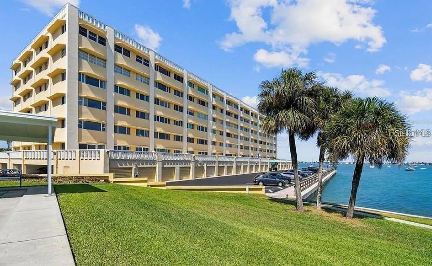 Enjoy resort-style waterfront living in this spacious 2-bedroom, 2-bath 55+ condo with a rare under-building garage space and additional storage, ideally located in the highly sought-after Harbour Club in Belleair Bluffs. Not all units offer this convenience, making it a valuable and hard-to-find feature.

This light-filled residence features a desirable split-bedroom floor plan for added privacy, along with beautiful wood flooring throughout the main living areas and tile flooring in all wet areas. The kitchen has been updated with granite countertops, offering both style and functionality for everyday living and entertaining.

The open living and dining area flows seamlessly into a cozy sitting space, where you can relax and take in tranquil water and pool views. Large windows throughout the unit bring in an abundance of natural light, enhancing the bright and airy feel of the home.

The spacious primary suite offers a walk-in closet and private ensuite bath, while the secondary bedroom is well-sized and perfect for guests or additional living space.

New hurricane-impact windows are scheduled to be installed prior to closing, or the seller is willing to provide a credit to the buyer—offering added value, protection, and peace of mind.

Harbour Club offers a true Florida lifestyle with amenities including a heated waterfront pool, fishing pier, clubhouse, fitness center, and beautifully maintained grounds. Located just minutes from the beach, shopping, and dining, this is the perfect opportunity to enjoy coastal living at its finest.  BRAND NEW AC