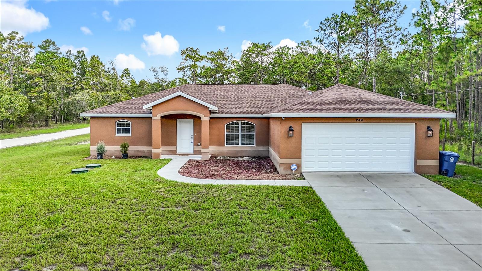 Why wait on builder delays when your dream home is ready right now? Built in 2023, this like-new beauty offers the freedom of no HOA or CDD—so go ahead, bring the boat, RV, or weekend toys and start living your Florida lifestyle to the fullest. Tucked on a generous corner lot just over half an acre, there’s room to roam, relax, and reimagine your outdoor space exactly how you’ve always envisioned it. Step inside and you’re instantly greeted by soaring ceilings, natural light, and life-proof vinyl plank flooring that flows throughout the open-concept living area. The kitchen is the true heart of the home, offering granite countertops, stainless steel appliances, and plenty of barstool seating space. Whether it’s a quiet dinner or a holiday gathering, the dining space just off the kitchen makes every meal feel special. The owner’s suite is a true sanctuary, with private patio access perfect for morning coffee. A large walk-in closet and spa-like ensuite bathroom with a dual sink vanity set in granite, and a frameless glass shower with floor to ceiling tilework complete the space. Two additional bedrooms and a full bath give everyone their own retreat, while the indoor laundry room provides added convenience. Outside, the covered patio opens to a massive backyard—just waiting for your firepit, garden beds, playset, or even that dream pool. Located near US-19 and the Suncoast Parkway, adventure is never far away. Paddle through 7 Sisters Springs, catch a magical mermaid show at Weeki Wachee, or soak up the sun at Buccaneer Bay. Here, every weekend feels like a staycation. Come see it for yourself and start your next chapter today.