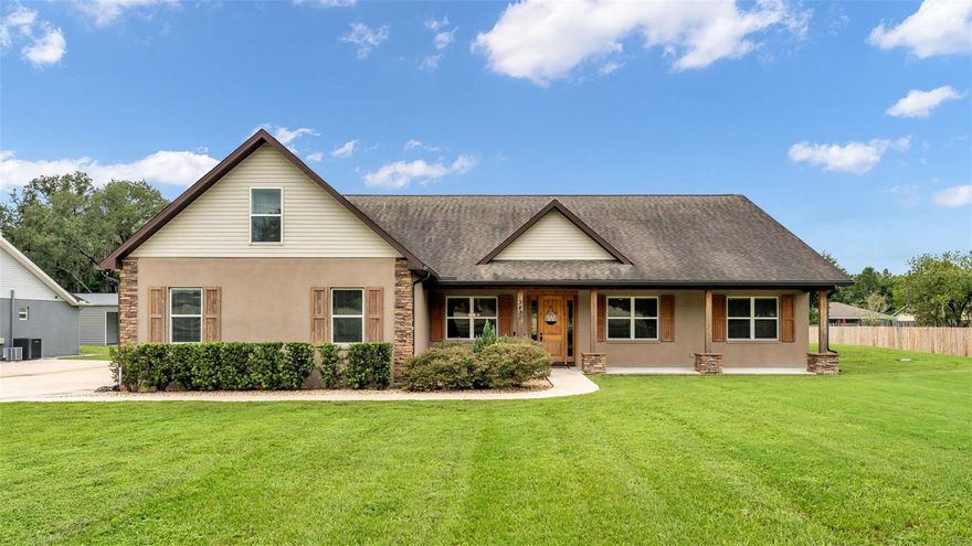 Presenting a modern farmhouse masterpiece that perfectly marries timeless charm with contemporary luxury, this exquisite residence—built in 2018 and proudly maintained by its original homeowners—offers an exceptional lifestyle on a beautifully manicured 1.15-acre lot at 3430 N Galloway Road in Lakeland, Florida. Boasting undeniable curb appeal with exterior stone accents and a striking façade, the home is nestled behind a spacious front yard that sets the tone for the elegance and serenity found within. Step inside to discover an expansive open-concept floor plan featuring 4 bedrooms, 3 bathrooms, with an office, formal dining space and a bonus flex room upstairs complete with its own half bathroom—perfect for a home gym, guest retreat, or media room. The living space is adorned with vaulted ceilings, a signature wooden beam that echoes the warm tones of the custom kitchen cabinetry, and a stunning stone fireplace with built-in shelving and a mounted TV as the focal point. Laminate wood-look flooring flows seamlessly throughout the home, creating a cohesive and stylish foundation for every room. The heart of the home is the abundantly sized kitchen, where an extra-spacious granite center island anchors the space and offers seating for gatherings and casual meals. Elegant touches like a gorgeous tiled backsplash, crown-molded upper cabinets, soft-close drawers, and recessed lighting elevate the kitchen's appeal. The adjacent dining and living areas flow effortlessly together, ideal for both entertaining and everyday living. The primary suite is a luxurious sanctuary, featuring a tray ceiling, and an extra-spacious walk-in closet with a custom organizing system and built-ins. The ensuite bathroom is a spa-like retreat, showcasing a dual-sink vanity and an elegant walk-in shower tiled to the ceiling, complete with two rain shower heads and a standard fixture for a truly indulgent experience. Additional highlights include a dedicated home office just off the foyer, a spacious laundry room with a built-in folding table, and a tri-split bedroom layout that ensures privacy for family and guests alike. Outdoors, enjoy Florida living to its fullest with an abundant outdoor space featuring a screen-enclosed lanai, a saltwater heated pool with a sunshelf, and a heated spa—all set on pavers and overlooking your serene backyard oasis. Car enthusiasts and hobbyists will appreciate the expansive 40x50 detached and enclosed workshop with electric, a single-bay garage, and a direct access door—alongside a three-car garage at the main residence, offering ample storage and functionality. This is modern farmhouse living at its finest—crafted with intention, detailed with sophistication, and designed for a lifestyle of comfort and elegance. Schedule your private tour today to experience this one-of-a-kind property.