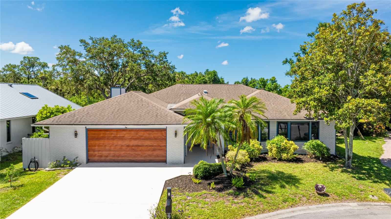 One or more photo(s) has been virtually staged. Completely updated and move-in ready, this stunning 3-bedroom, 2.5-bath pool home in the highly coveted Woodland Park neighborhood offers the total package: privacy, modern design, nature views, and unbeatable location. Tucked at the end of a quiet cul-de-sac on a waterfront lot, this home has been thoughtfully renovated from top to bottom with a new roof (2020), a fully remodeled kitchen and bathrooms (2020), quartz countertops, fresh interior paint (2020), exterior paint (2024), updated lanai and driveway (2023), plus luxury vinyl plank and tile flooring throughout. The open-concept layout showcases a showstopping chef’s kitchen with custom cabinetry, stainless steel appliances, oversized island, designer backsplash, walk-in pantry, and built-in coffee bar. Pocketing sliders lead to your expansive covered lanai and screened-in heated pool and spa, all overlooking a tranquil pond and lush preserve—no rear neighbors, just serene nature and Florida wildlife. The spacious living room is anchored by a custom wood-burning fireplace with live-edge cocobolo mantle and stacked stone surround, while a second living area and formal dining room provide flexible space for entertaining. The split-bedroom design features a luxurious primary suite with private pool access, walk-in closet, and spa-like bath with soaking tub and walk-in shower. Two guest bedrooms share a beautifully updated Jack and Jill bath, plus there's a separate half bath with pool access. A dedicated laundry room and oversized 2-car garage complete the home. Woodland Park is one of Sarasota’s best-kept secrets, offering enchanting canopy roads, access to the Legacy Trail, and a peaceful setting just 15 minutes to downtown Sarasota and 20 minutes to Siesta Key’s world-renowned beaches. **THIS PROPERTY QUALIFIES FOR A 1% LENDER INCENTIVE IF USING PREFERRED LENDER. INQUIRE FOR MORE DETAILS.**