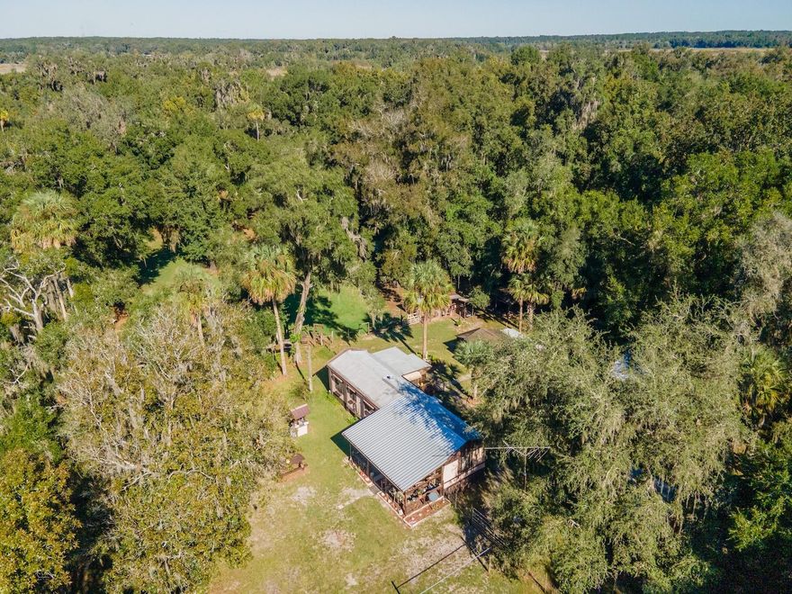 Mini Farm with Canal Access – 15429 NE 38 Court, Citra, FL 32113
2 Bedrooms | 1 Bathroom | 756 Sq Ft | 3.05 Fenced Acres | Barns, Sheds & Pastures

Welcome to your own mini farm retreat located in the Black Sink Prairie area of Citra, Florida! This charming property sits on 3.05 fully fenced acres with canal access (currently low water level) and a gated entrance that opens to a peaceful countryside setting surrounded by horse farms and open pastures.

The property features two fenced paddocks, a 2-stall barn with tack room, and water at the corrals—perfect for horse lovers or hobby farmers. The 1987 mobile home offers 2 bedrooms, 1 bathroom, and 756 sq ft of cozy living space. The kitchen includes with plenty of cabinet and counter space. The open living area is spacious, featuring laminate, vinyl, and carpet flooring throughout.

Enjoy your morning coffee on the 11’x24’ covered front porch while watching the birds and squirrels, or unwind in the 7’x15’ screened porch overlooking the peaceful back acreage and trees.

Outdoors, you’ll find a 20’x20’ covered carport, a 20’x24’ horse barn, 22’x15’ and 17’x9’ open sheds, and a 12’x16’ utility building with an attached lean-to—ideal for mowers, yard tools, or seasonal storage. All major outbuildings include power and water connections. The home has a private well and septic system.

Located in the quaint town of Citra, famous as the home of the Pineapple Orange, you’ll find small-town charm with unique attractions like The Orange Shop, Crones Cradle Conserve, and Skunkie Acres horseback riding. Only a short drive to Ocala or Gainesville, this mini farm offers the perfect balance of country tranquility and convenience.

This is your chance to enjoy affordable country living with room for animals, hobbies, and relaxation—a true hidden gem in Marion County’s horse country!