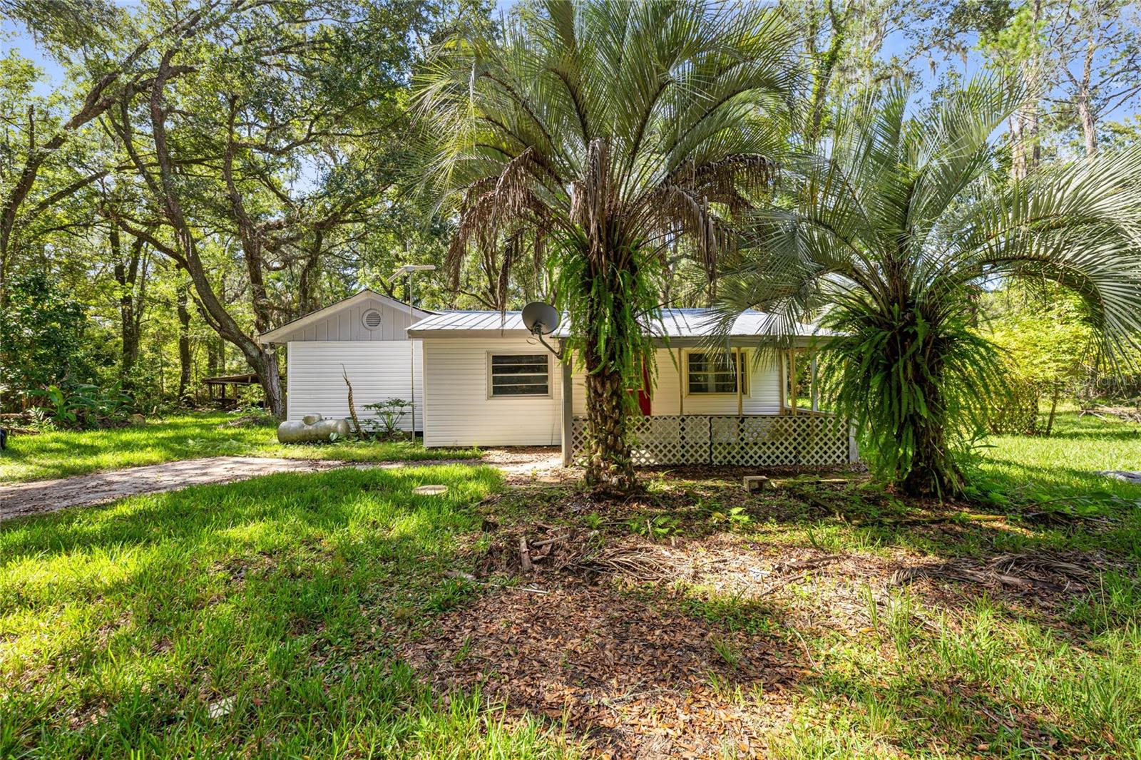 Cozy cottage home that is perfect for INVESTORS or as a starter home! Tons of privacy in a beautiful setting. The METAL ROOF was recoated 8 years ago and the interior has been UPDATED. The exterior VINYL SIDING was also replaced. This home sits on 1.66 acres with power septic for a mobile home. Located just minutes from Gainesville Regional Airport and not too far from shopping, this is country living that's not too far out!