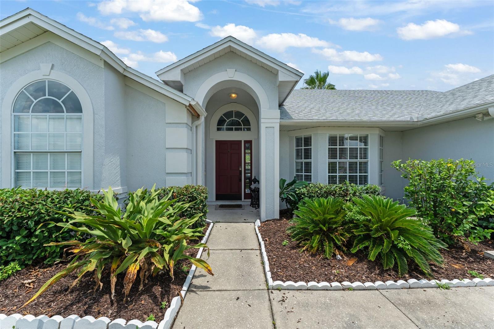 **This property qualifies for a closing cost credit up to $4,900 through the Seller’s preferred lender.** Stylish and Spacious Kissimmee Retreat with Modern Upgrades and Split Floor Plan. Welcome to 121 Country Creek Lane, a beautifully updated 3-bedroom, 2-bathroom home with 1,600 sq ft of living space and a 2-car garage, nestled in a quiet neighborhood just minutes from shopping, dining, and entertainment. This thoughtfully designed home offers the perfect balance of comfort, style, and functionality. As you step inside, you’re immediately greeted by an open-concept layout that connects the living room, dining room, kitchen, and family room—creating an airy, spacious feel that's perfect for everyday living and entertaining. The dining area features a modern chandelier, a charming bay window overlooking the front yard, and convenient garage access just steps away. The heart of the home—the kitchen—is a true showstopper with sleek black glossy cabinetry, a waterfall-edge countertop with breakfast bar seating, stainless steel appliances, and even a mini fridge for added convenience. Adjacent to the kitchen, the family room and galley-style layout are enhanced by vaulted ceilings and a decorative wall niche, while glass sliding doors lead out to the covered patio, blending indoor and outdoor living beautifully. Tucked between the kitchen and family room is a hallway leading to two guest bedrooms, both with laminate flooring and built-in closets. The guest bathroom is a stylish standout with floor-to-ceiling gray tile, a glass-enclosed walk-in shower, and even direct access to the backyard—perfect for guests or post-swim rinses if you envision adding a pool. On the opposite side of the home, the primary suite offers a peaceful retreat with vaulted ceilings, private access to the patio, a spacious walk-in closet, and an elegant ensuite bath featuring a dual-sink vanity, a step-in soaking tub, and a separate glass-enclosed shower. Step outside to the covered patio—a quaint, shaded space overlooking the blank canvas backyard, ready for your personal touch. Whether you’re dreaming of a garden, outdoor kitchen, or sparkling pool, the possibilities are endless. Modern touches, an open layout, and plenty of room to grow—this Kissimmee gem is ready to welcome you home.