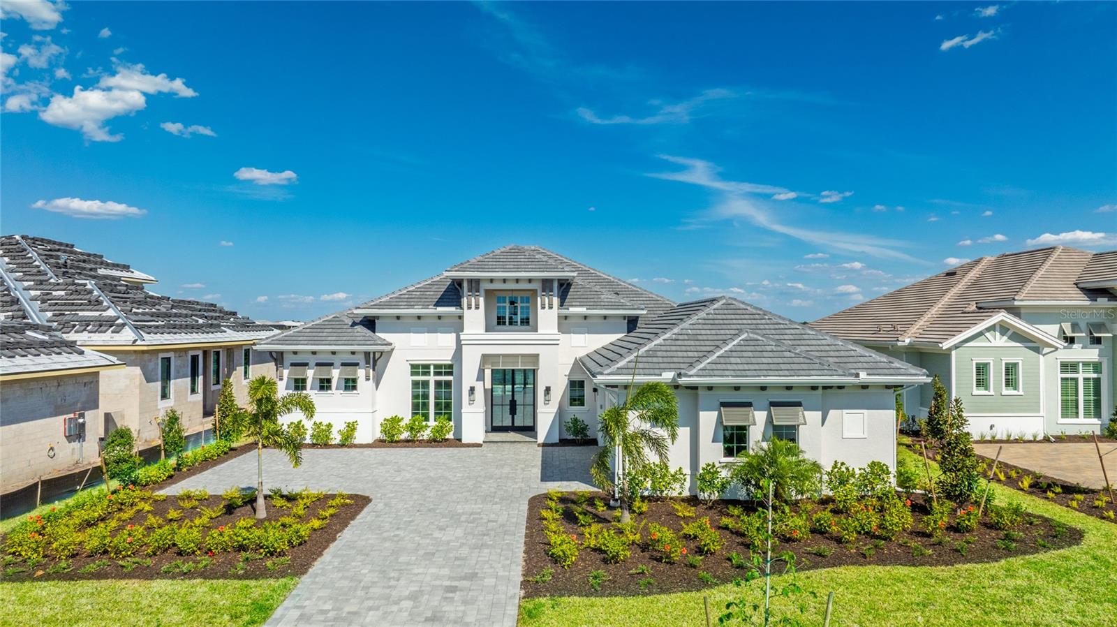 Step into luxury with the award-winning Gardenia II floorplan, offering over 4,000 square feet of air-conditioned living space and nearly 1,000 square feet of covered outdoor living. This stunning residence features four bedrooms, each with its own en-suite bath, plus a stylish powder room, private study, and a spacious bonus room perfect for entertaining or relaxing. The wide-open layout blends indoor and outdoor spaces seamlessly, making it ideal for both everyday living and grand gatherings.
Situated on an oversized lot with sweeping, mile-long water views, this home is perched along the “big lake” in Wild Blue at Waterside—Lakewood Ranch’s most sought-after new luxury community, now sold out of new build opportunities on this coveted stretch. The outdoor living area is a true showstopper, featuring a sparkling pool with spa, sun shelf, and decorative water bowls, along with a gourmet outdoor kitchen and a cozy fireplace. The expansive bonus room opens directly to the covered lanai, creating the perfect flow for indoor-outdoor entertaining under the Florida sun.
Inside, the light-filled den captures some of the home’s best views, while the primary suite serves as a serene retreat with a spa-like bathroom bathed in natural light. Soaring 15-foot ceilings and elegant ceiling treatments in the entryway, great room, primary bedroom, office, and dining room add architectural charm, while rich wood floors throughout enhance the warmth and sophistication of the space. Every detail reflects the signature luxury and craftsmanship showcased in Stock Luxury’s most celebrated model homes.
Ideally located just a golf cart ride away from Publix, Starbucks, Libby’s, Waterside Place, and all the best of Lakewood Ranch, this home offers more than just comfort—it delivers a lifestyle. Wild Blue at Waterside features resort-style amenities not yet seen elsewhere in the region, setting a new standard for luxury living. This home is competitively priced with new construction—but unlike the rest, it’s move-in ready. Don’t miss your chance to own a piece of paradise.