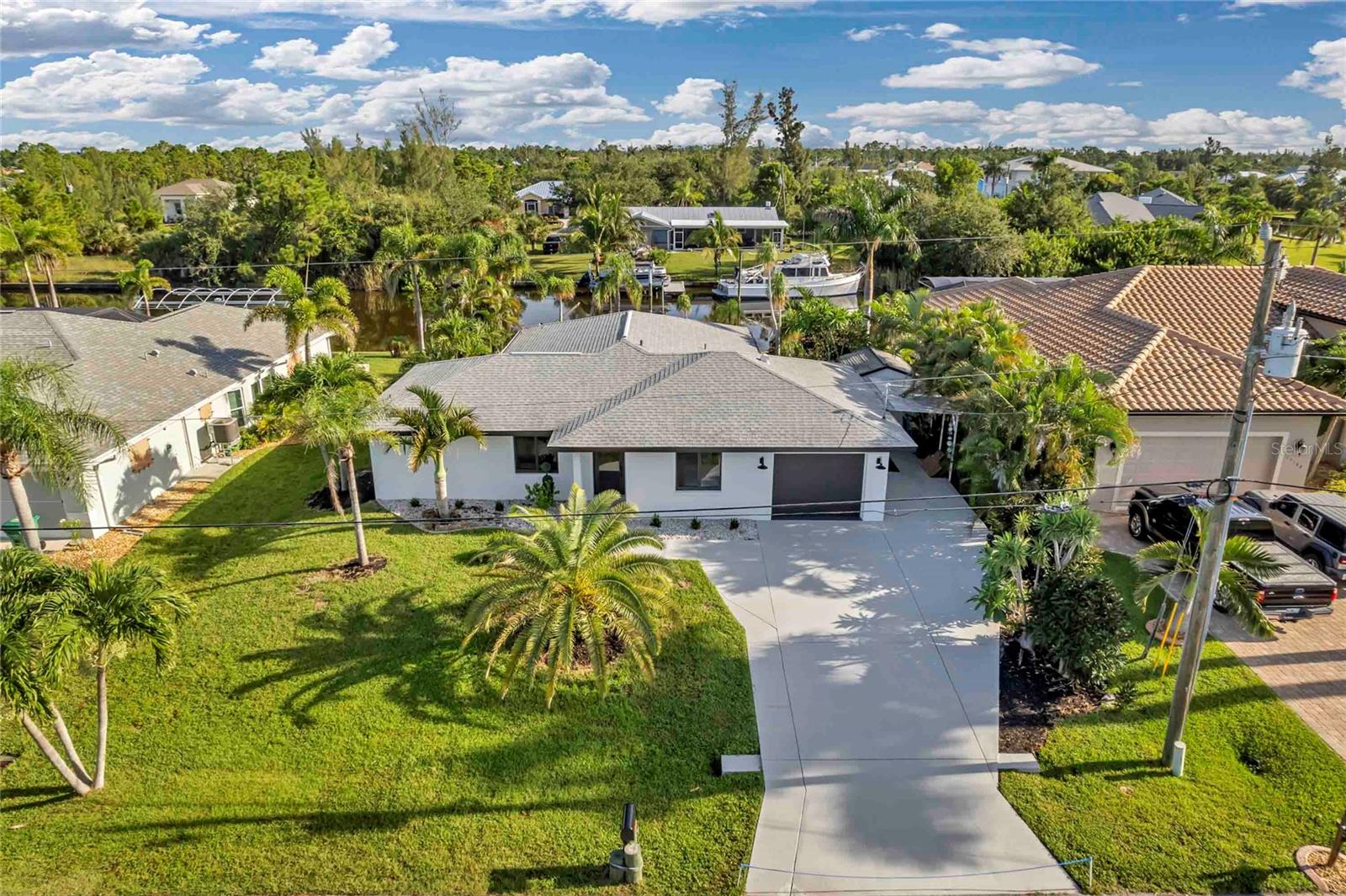 NEVER FLOODED! WOW-FACTOR WATERFRONT! Whole house luxury renovation just completed August 2025. Fully renovated CBS canal-front home with 2,043 total square feet, featuring all-new construction with impact windows/doors; Sub-zero, Miele, & Bosch appliances; smart thermostat; endless hot water system; EV charger; reverse osmosis drinking water; spa-style Japanese Bidet toilets; zero threshold showers; solid wood cabinetry; natural stone counters, smooth drywall/stucco; putting green; newer roof & AC. 24x48 porcelain floor tile throughout for a sleek, modern look and easy maintenance. Fresh landscaping enhances curb appeal and provides a welcoming atmosphere. Custom closets throughout provide ample storage space. City water/sewer. Optional HOA $10/mo. Sailboat access, no bridges, 80’ wide frontage with direct Gulf access. New dock, concrete seawall, & private community lock system protects against tide swings & flooding. Minutes to Boca Grande beaches, golf, & Placida shops. KEY WEST themed carport offers even more outdoor living space. Enjoy multi-million-dollar finishes in a manageable size & affordable package, plus a 900 square foot screened lanai for seamless indoor-outdoor living. Ideal full-time or seasonal retreat. Showings by boat welcome!