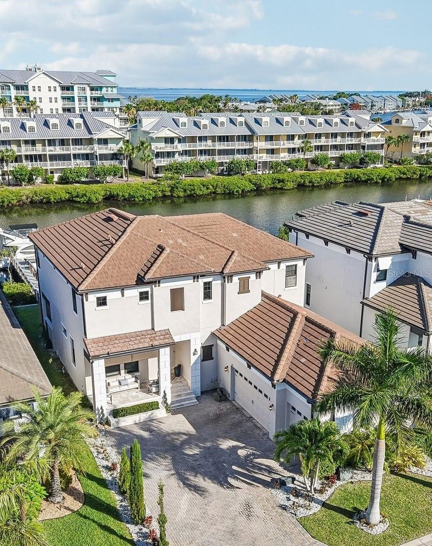 Welcome to Antigua Cove a coastal waterfront community where luxury living meets effortless elegance. Be amazed by this meticulously styled 3-bedroom, 3.5-bath home offering over 3,180 sqft. with an expansive open floor plan designed for comfort, functionality, and entertaining. With 12ft ceilings and tile on the main floor, this home is bright, inviting and the open floor plan allows a seamless flow throughout. Several features make this home unique and like no other which includes:

(1) Dine in a gourmet style kitchen which features 42” cabinetry with crown molding, soft close doors, modern GE appliances, an oversized island with ample seating/storage and beautiful tile flooring.
(2) An owner's retreat with porcelain tile floors, a spa-like steam shower, deep jetted soaking bathtub, a full sauna, dual vanities, and spacious/separate walk-in closets.
(3) Large sliding glass doors open to an incredible oversized lanai, complete with an outdoor kitchen featuring a farm sink, 6 burner gas Napoleon Grill, Wine Refrigerator, built in Hibachi Grill and a Projector/Screen. This is the perfect place for hosting movie nights or relaxing while enjoying breathtaking water views. Additionally, this space boast’s luxurious custom designed outdoor bar area with seating, a TV, a sink, bar-height refrigerators, and an ice machine.
(4) A private elevator allows for simple, quick and easy access from the garage to the second level of the home.
(5) A private boat dock with a large sitting area, allowing for up to a 45ft boat, and a 20,000lb boat lift. This feature of the home delivers easy access for navigating, fishing and boating excitement through the west coast of FL waterways.

Community amenities include a clubhouse, fitness center, media rooms, pool, tennis and pickleball courts, bocce, onsite sand beach with water sports rentals, two restaurants, two marinas with Freedom Boat Club options, a playground, a newly constructed fishing pier, and fishing charters. This exceptional home delivers the perfect blend of elegance, comfort, and coastal lifestyle. Schedule your private showing today—this home will not last long. Buyer to verify all measurements.