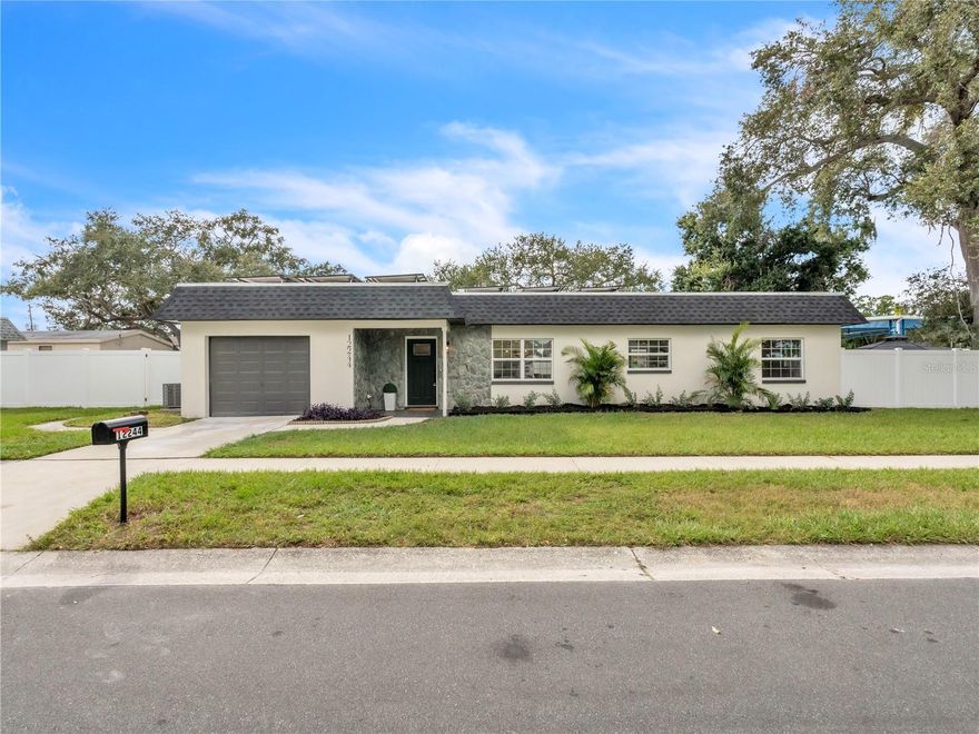 Welcome to this beautifully reimagined 3-bedroom, 2-bath residence, perfectly situated high and dry in the heart of Largo! Step inside to discover an open-concept living space filled with natural light, featuring brand-new LVP flooring and a seamless flow between the living, dining, and kitchen areas. The stunning kitchen is the centerpiece of the home, showcasing a large island with quartz countertops, soft-close shaker cabinets, and stainless steel appliances—perfect for cooking, gathering, and entertaining. The spacious primary suite offers a beautifully tiled ensuite bathroom with a modern walk-in shower, while the guest bath features professionally curated tile that adds charm and character throughout. The oversized single-car garage provides ample room for parking, storage, or a workshop area. Step outside to your own private oasis—a fully fenced backyard featuring a custom mural on the perimeter wall that brings a splash of color and personality to the space. The patio area is perfect for grilling, relaxing, or hosting friends and family for outdoor gatherings. Enjoy peace of mind with major updates including updated roof components (2025), brand-new HVAC ductwork (2025), PAID OFF solar panels (2021), and a new water heater (2025). Conveniently located near shopping, dining, and just a short drive to Florida’s world-famous Gulf beaches, this home blends contemporary design with everyday comfort. Come see why this beautifully updated Largo home is the perfect place to call your own!