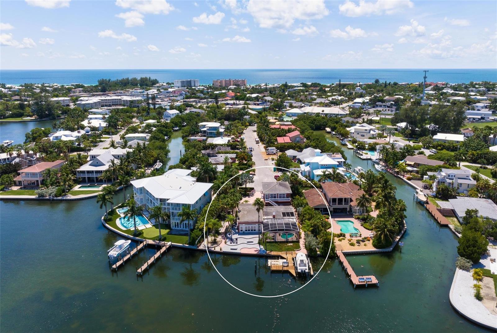 Come build your dream home! Boasting 110 feet of direct frontage on the Intracoastal Waterway with deep-water dockage, this spectacular Holmes Beach property offers an incredible opportunity to build your dream home on Anna Maria Island. Whether you choose to start fresh with new construction or renovate, the one-third of an acre property is perfectly positioned on a quiet street for relishing a serene island lifestyle, with magnificent water and sunrise views. The home features 5 bedrooms, including a master suite and a separate 2-bedroom, 1.5-bath guesthouse with a living room and full kitchen. The open floorplan living and dining room transition to a screened lanai with a pool, built-in grill, paver deck and covered areas. Come relax and dine alfresco while enjoying the picturesque scenery. Beyond the lanai, there is a boat lift, a floating Jet Ski lift and a dock for all your waterway adventures. Exterior highlights include an oversized two car garage, paver driveway and paved walkways. Don’t miss an amazing opportunity to build your new dream home and make this your own picturesque island sanctuary.