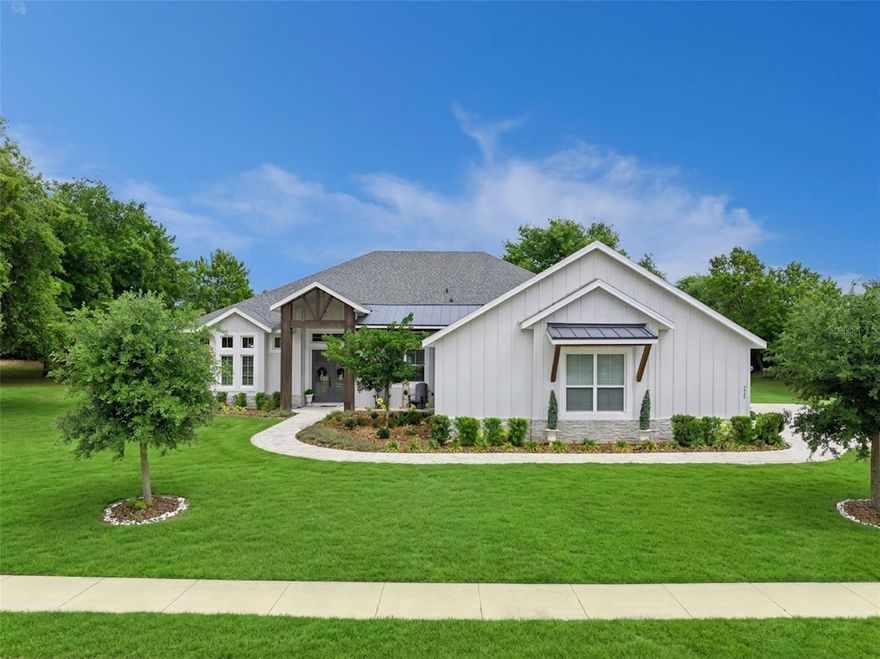 Welcome to your dream home in Crooked Lake Reserve, a peaceful, friendly, low-HOA community offering serene views of West Crooked Lake and an unbeatable location just minutes from downtown. Built in 2022, this stunning Kevco "Valencia Farmhouse" model blends modern design with timeless farmhouse charm. Situated on an oversized .58-acre lot, this 4-bedroom, 3-bath home stands out immediately with its rare 3+ car garage, offering incredible flexibility for extra vehicles, a golf cart, workshop space, or even boat/RV storage. Step inside and you're greeted by elevated craftsmanship throughout, including tray ceilings, 5-1/4" crown molding and baseboard trim, and wood beam accents, all paired with a bright open layout and luxury vinyl tile flooring throughout, NO CARPET anywhere. A built-in electric fireplace creates a warm, modern focal point in the main living area. The chef's kitchen is designed to impress, featuring quartz countertops, a large center island, ceiling-height cabinetry, and soft-close finishes, making it equally perfect for entertaining and everyday living. The thoughtfully designed split-bedroom floor plan offers ideal privacy, while the primary suite feels like a true retreat with a soaking tub, double vanities, and a spacious walk-in shower. Every closet in the home has been upgraded with custom-built shelving for maximum organization and style! One of the true showpieces of the home is the expansive stacking slider with remote-control blinds, seamlessly blending indoor and outdoor living. Step outside to the screened-in, fully tiled patio, an ideal space to relax or entertain, with plenty of room to add your dream pool in the fully fenced backyard. Recent upgrades include a vinyl privacy fence along the rear, rod iron fencing on the sides, new flooring in the guest bedrooms, and a newly tiled screened-in patio, enhancing both function and curb appeal. Located just 1.5 miles from downtown Eustis and only 4 miles from downtown Mount Dora, you'll enjoy quick access to dining, shopping, and local charm, with convenient access to US-441 for everyday needs. Beautiful interior and exterior, tons of space, and a highly desirable location, this one has it all! Some photos have been virtually staged.