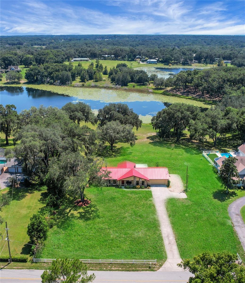 Welcome home to this gorgeous 1.63 Acre Lakefront home nestled just 10 minutes to The Villages but surrounded by nature and overlooking Lake Hermosa. This 3/2 with bonus room has a new metal roof (2022), New Water Heater (2022), New Well Pump (2024), Exterior & Interior painted (2022), New Engineered Hardwood Floors (2022), New Washer & Dryer (2022), New Shed/Workshop (2023) and the HVAC is 2009. From the moment you walk in the door, you see the beautiful views of the lake. This 3 bedroom, 2 1/2 bath, 2 car garage home has 1890 sq ft heated with 2918 total sq ft. There is both a dinette area overlooking the Lake as well as a formal dining area for entertaining guests. The lanai is perfect for enjoying the outdoors while taking in the beautiful views! Beyond the Inside Laundry Room and the 1/2 Bath (great for guests) is a bonus room which could be an exercise room, craft room or office area. Plenty of room to bring your animals & toys!