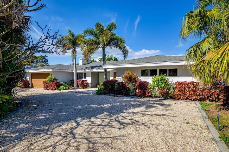 A rare opportunity to own a beautifully preserved home where timeless design meets peaceful waterfront living. With clean architectural lines, an open layout, and mint-condition original features, this residence offers both character and comfort in a serene lakeside setting.

Lush, private tropical landscaping frames the front of the home, creating a welcoming sense of arrival. Out back, a stunning 969-square-foot screened lanai overlooks tranquil Lake Flory, offering the perfect place to relax, entertain, or enjoy the calming water views.

Inside, a spectacular open-concept living, family, and dining space flows seamlessly into the updated kitchen. The main living area showcases distinctive design details including a striking triangular fireplace, period-specific light fixtures, and a built-in wall aquarium that adds a unique architectural touch. The kitchen features a charming custom banquette with a newly upholstered seat—ideal for casual dining or morning coffee.

The spacious primary suite enjoys beautiful water views and includes custom louvered closet doors with built-in drawers, along with an en-suite bathroom in pristine original condition. A second generously sized bedroom connects to another beautifully maintained vintage bathroom. The third bedroom is privately located on the opposite side of the home with its own bathroom, offering flexibility as a guest suite, home office, or creative workspace.

Designed for both comfort and convenience, the home includes custom remote-controlled electric roller shades, a Wi-Fi–enabled thermostat, speakers throughout, and multiple lighting options to create the perfect ambiance.

The newly constructed lanai is not only expansive but also hurricane-rated to 160 mph. This outdoor living area features a cozy fireplace, a handcrafted broken-tile mosaic table and bar area, and built-in planters—perfect for gathering with friends or enjoying quiet evenings by the water.

Additional highlights include a large laundry room, custom closet shelving, landscape lighting, a sprinkler system, a hurricane-impact front picture window, and hurricane shutters for the remainder of the home.

Ideally located just minutes from the beach, the bridge, and nearby boat ramps, this home offers a unique blend of architectural character, thoughtful upgrades, and relaxed coastal living.