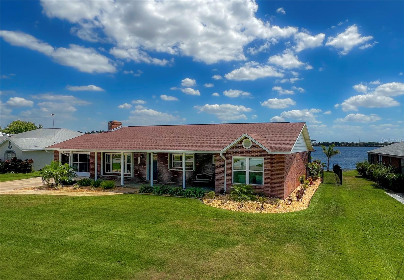 Discover the perfect blend of luxury and tranquility in this exquisite lakefront home, nestled within the sought-after Rivergreens golf course community. With breathtaking views of Lake Damon, this property offers the ideal backdrop for both sunrise and sunset moments. This charming brick home features an inviting inground pool with screened enclosure, perfect for entertaining or simply relaxing while soaking in the beautiful scenery. The thoughtfully reconfigured kitchen boasts stylish navy-blue soft close cabinets and elegant granite countertops, complemented by a matching office area that overlooks the pool and serene lake. Flowing seamlessly throughout, the entire home showcases new luxury vinyl plank flooring, providing a modern touch. Recent upgrades include brand new windows and a new front door (2023), new interior doors, fresh paint, updated lighting, a new electric hot water heater, a new pool filter (2024), and a newly installed pool heater (2023). Both the roof and pool liner were updated in 2023, ensuring peace of mind for the new homeowner. The two-car garage is equipped with sliding skeeter beater screens, allowing you to enjoy the outdoors without pesky bugs. A new chain-linked fence has been installed along the sides of the home. The master bathroom features new granite counter tops and boasts a generously sized walk-in closet. The hall bathroom also has a new vanity with gorgeous marble counter tops. Enhancing the enjoyment of lake life, a new dock has been added, and the seawall has been reinforced. New fresh, low maintenance landscaping recently added including lush palm trees. A rare find in Florida, this home also includes a brick fireplace currently fitted with an electric fire, adding warmth and charm to the living room. With two bedrooms and two bathrooms, this generously sized residence on the shores of Lake Damon offers a lifestyle of comfort and leisure. Don't miss your chance to experience all that this exceptional home has to give—schedule your private showing today!