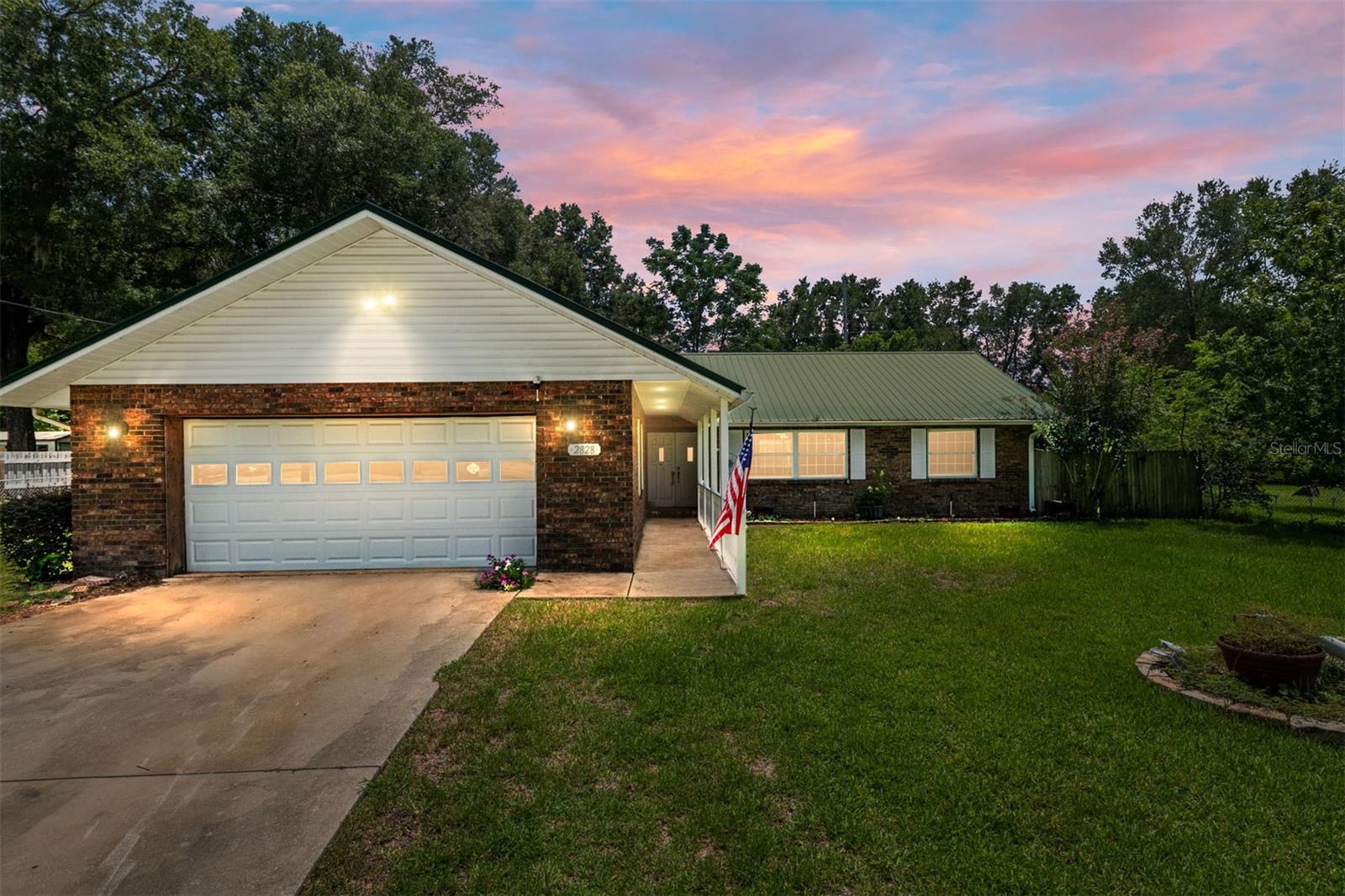 Save on your electric bill with solar power while enjoying your own private oasis! Set on an oversized, fenced 0.42-acre lot with a metal roof, this single-story brick home offers the perfect blend of indoor comfort and outdoor living. The centerpiece of the property is a beautiful screened-in pool and spacious porch area.. your own private oasis for relaxing or entertaining. Solar panels help keep electric bills LOW, while mature trees and lush landscaping create a peaceful, park-like setting. Inside, you’ll find bright, open living spaces with hardwood-style flooring, soft gray walls with white trim, and abundant natural light. The updated kitchen features stainless steel appliances, white cabinetry, and terracotta tile floors that flow into a bay-window dining nook. The spa-inspired bathroom includes natural stone tile, a soaking tub, a walk-in shower, and elegant mosaic accents. With its thoughtful upgrades, exceptional outdoor amenities, and expansive lot, this home is a rare find.